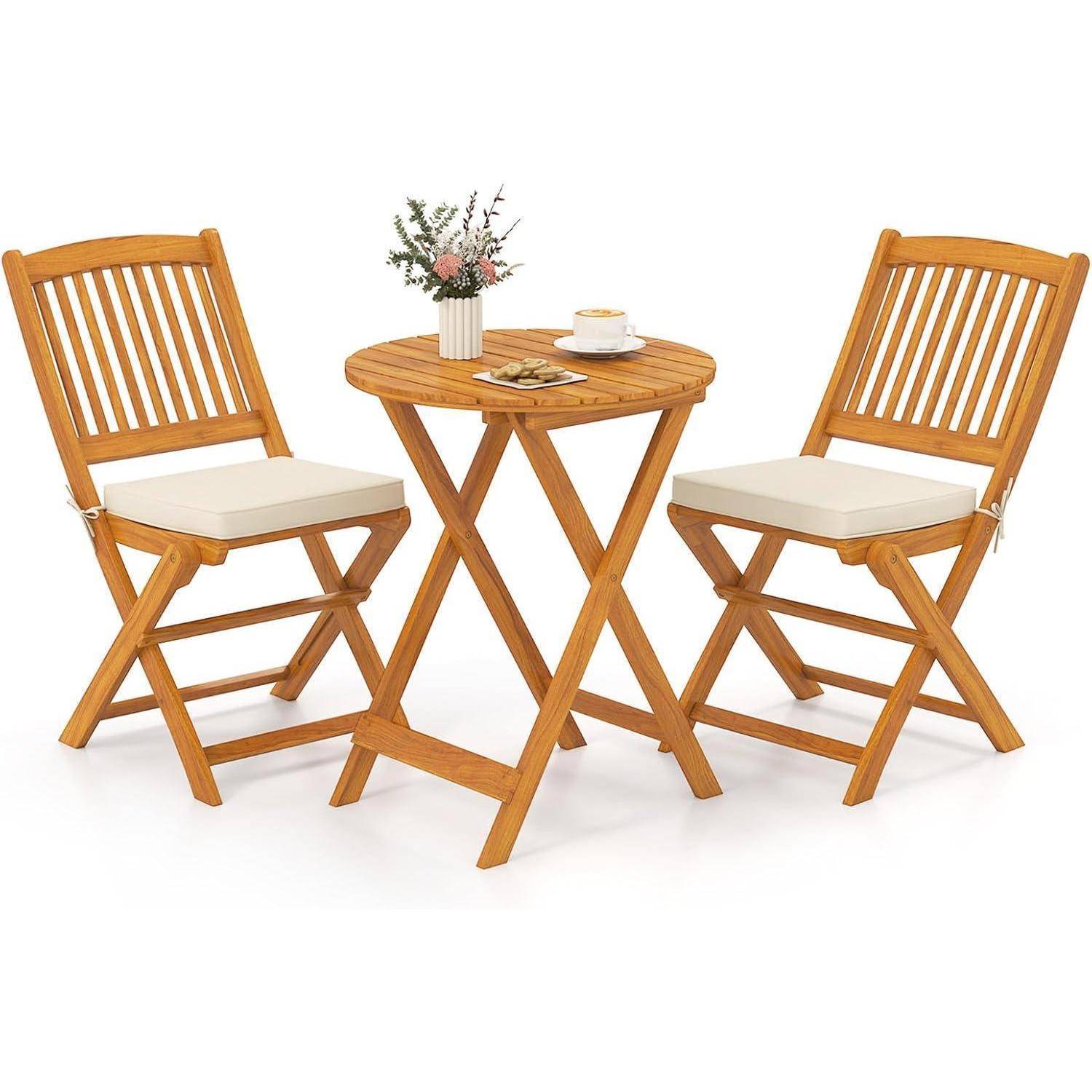Ein kleiner Holz-Gartenmöbel-Set mit zwei Stühlen und einem runden Tisch. Eine Tasse und eine kleine Blumenvase stehen auf dem Tisch und schaffen eine gemütliche Outdoor-Atmosphäre.
