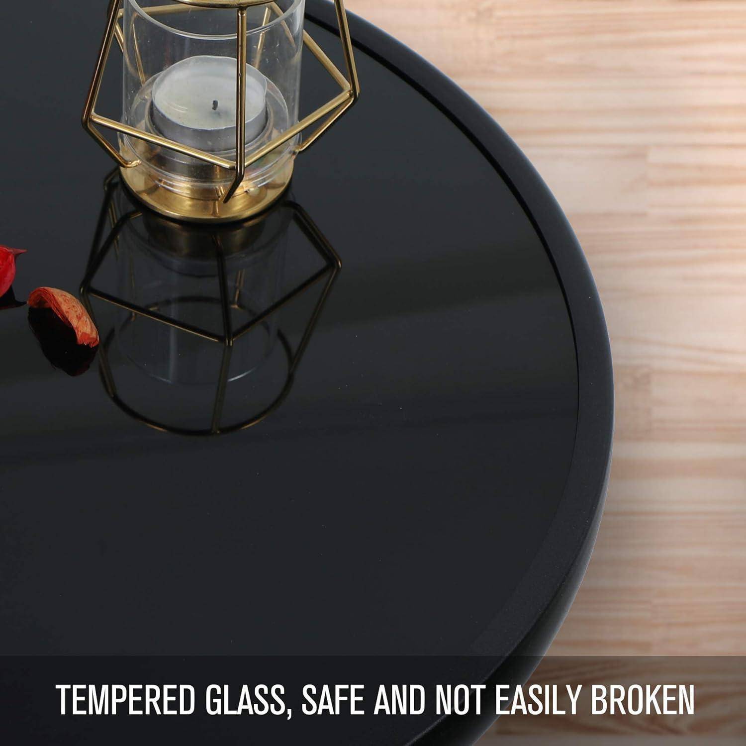 Ein runder Tisch mit einer glänzend schwarzen Glasplatte aus gehärtetem Glas trägt einen kleinen goldgerahmten Kerzenhalter. Der Text lautet: „Gehärtetes Glas, sicher und nicht leicht zerbrechlich