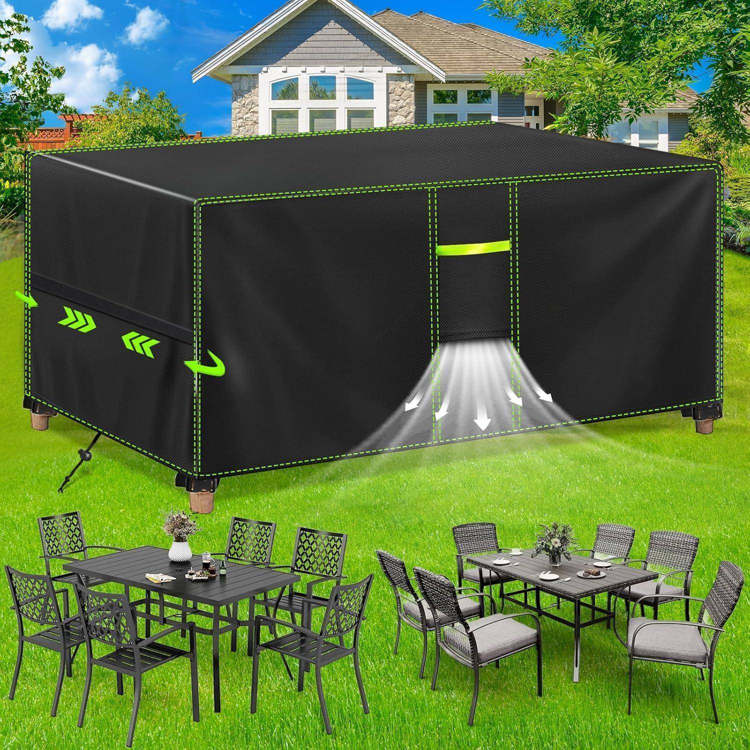 Eine schwarze Outdoor-Möbelabdeckung schützt einen Terrassentisch und Stuhlset, wobei ein Haus und Garten im Hintergrund sichtbar sind.