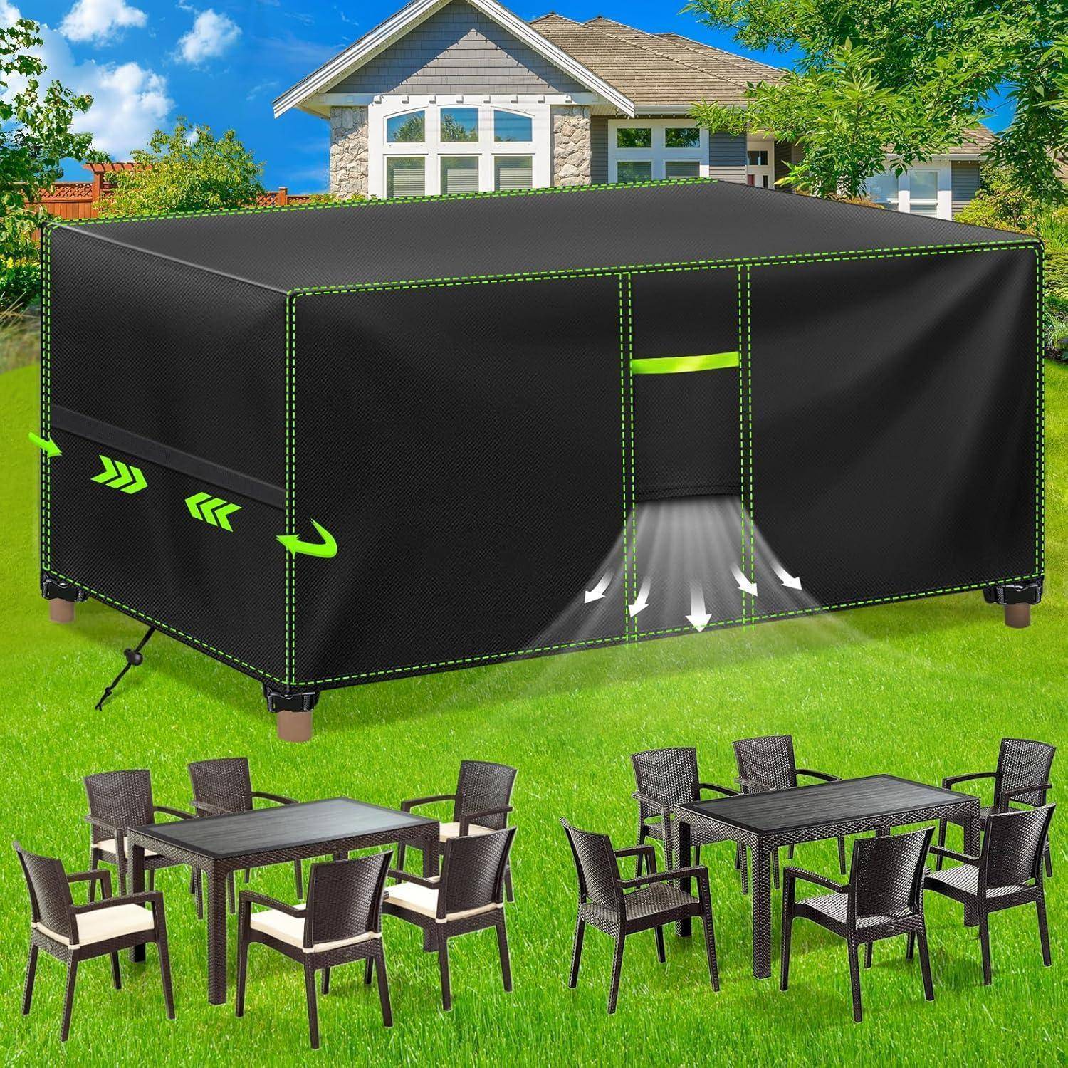 Ein großes schwarzes Outdoor-Zelt mit grünen Akzenten ist auf einem Rasenplatz vor einem modernen Haus aufgebaut. Zwei Gartenmöbel-Essgruppen mit Stühlen sind in der Nähe platziert.