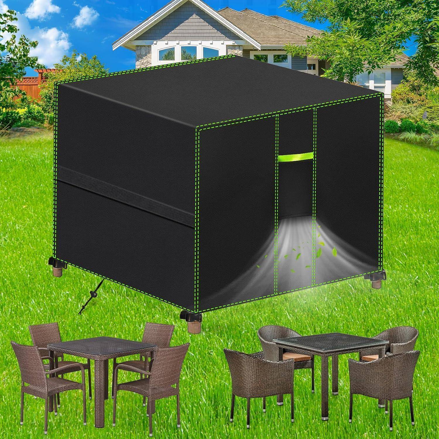 Eine schwarze Outdoor-Möbelabdeckung über einer Terrassenmöbelgruppe in einem grünen Garten. Die Abdeckung ist geöffnet und gibt die Möbel frei. Ein Haus ist im Hintergrund sichtbar.