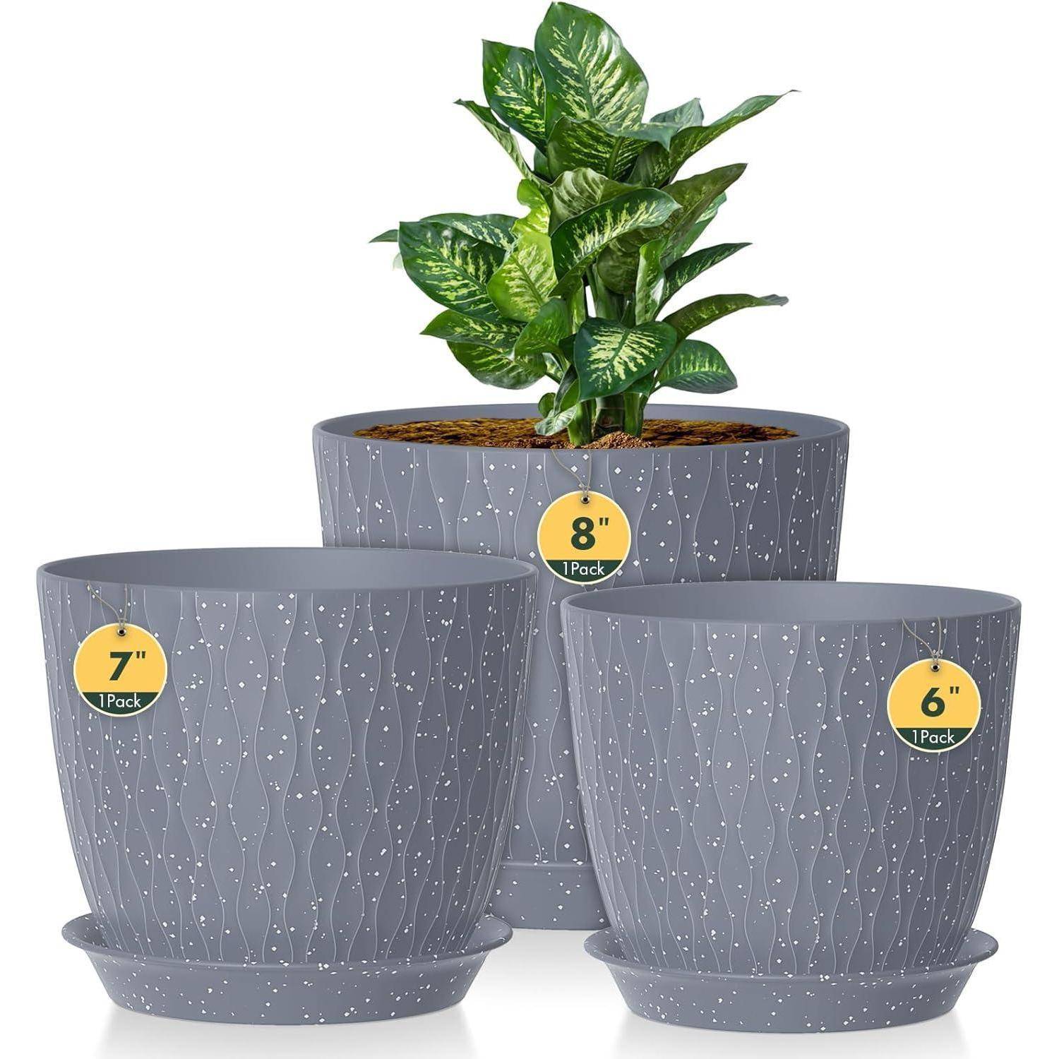 Drei graue Pflanzentöpfe mit weißen Sprenkelmuster, in den Größen 15 cm, 18 cm und 20 cm. Der größte Topf enthält eine üppige grüne Pflanze.