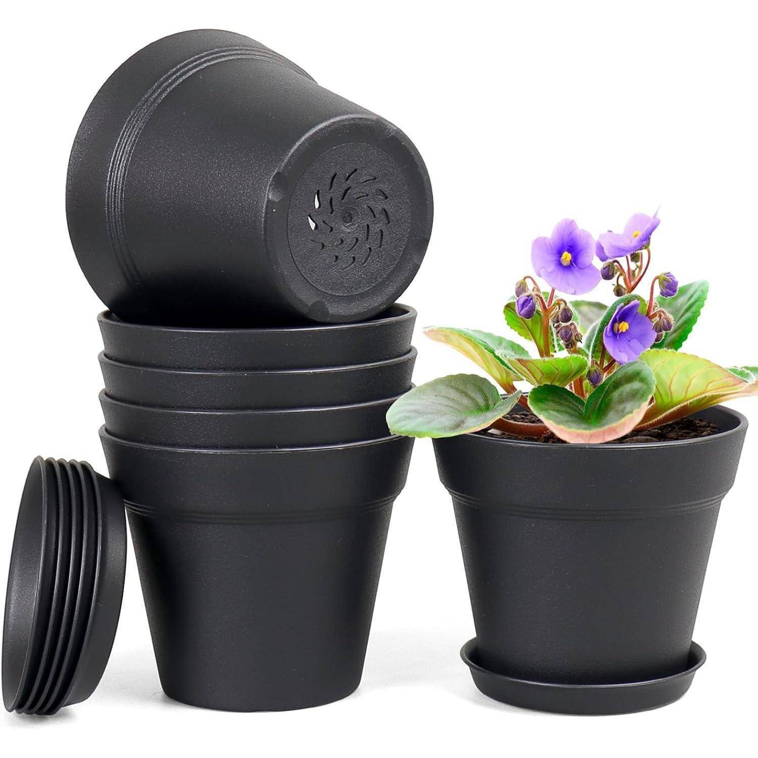 Ein Stapel von fünf schwarzen Plastikblumentöpfen neben einer Topfpflanze mit violetten Blüten in einem ähnlichen schwarzen Topf.
