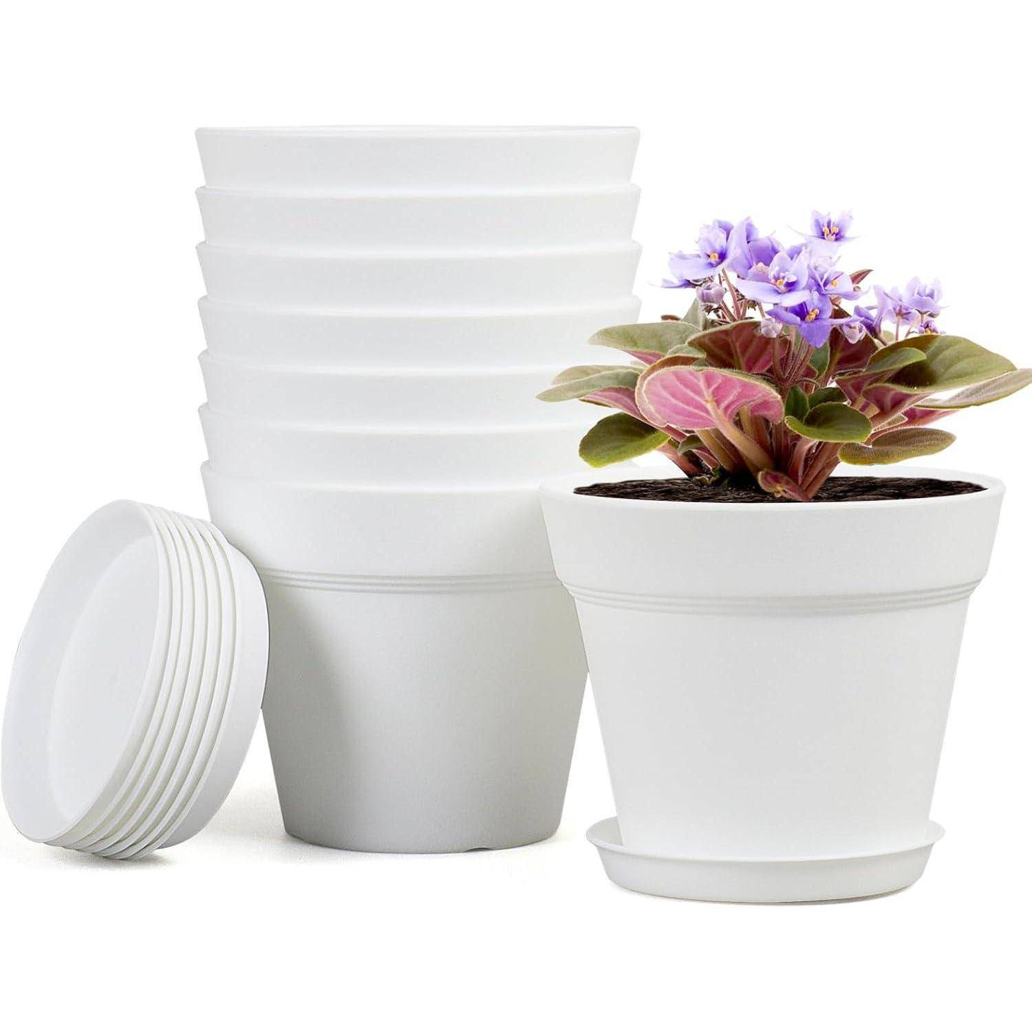 Ein Stapel weißer Pflanzentöpfe mit einer einzelnen, mit einer lila blühenden Pflanze bepflanzten Topf im Vordergrund.