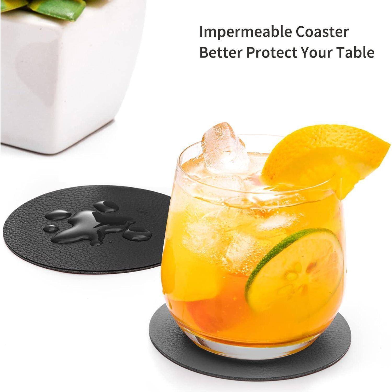 Ein Glas mit eisigem Orangen- und Limettendgetränk auf einem schwarzen Untersetzer mit dem Text 