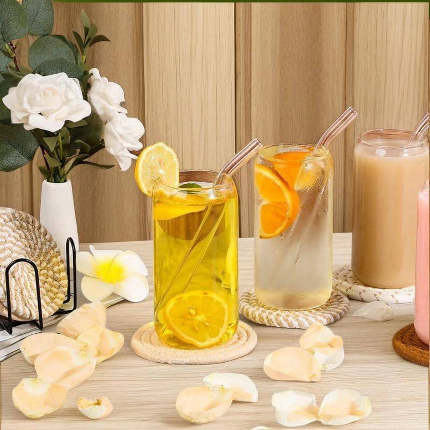 Drei erfrischende Getränke auf Untersetzen: ein gelbes Getränk mit Zitronenscheiben, ein klares Getränk mit Orangenscheiben und ein rosa Milchshake.