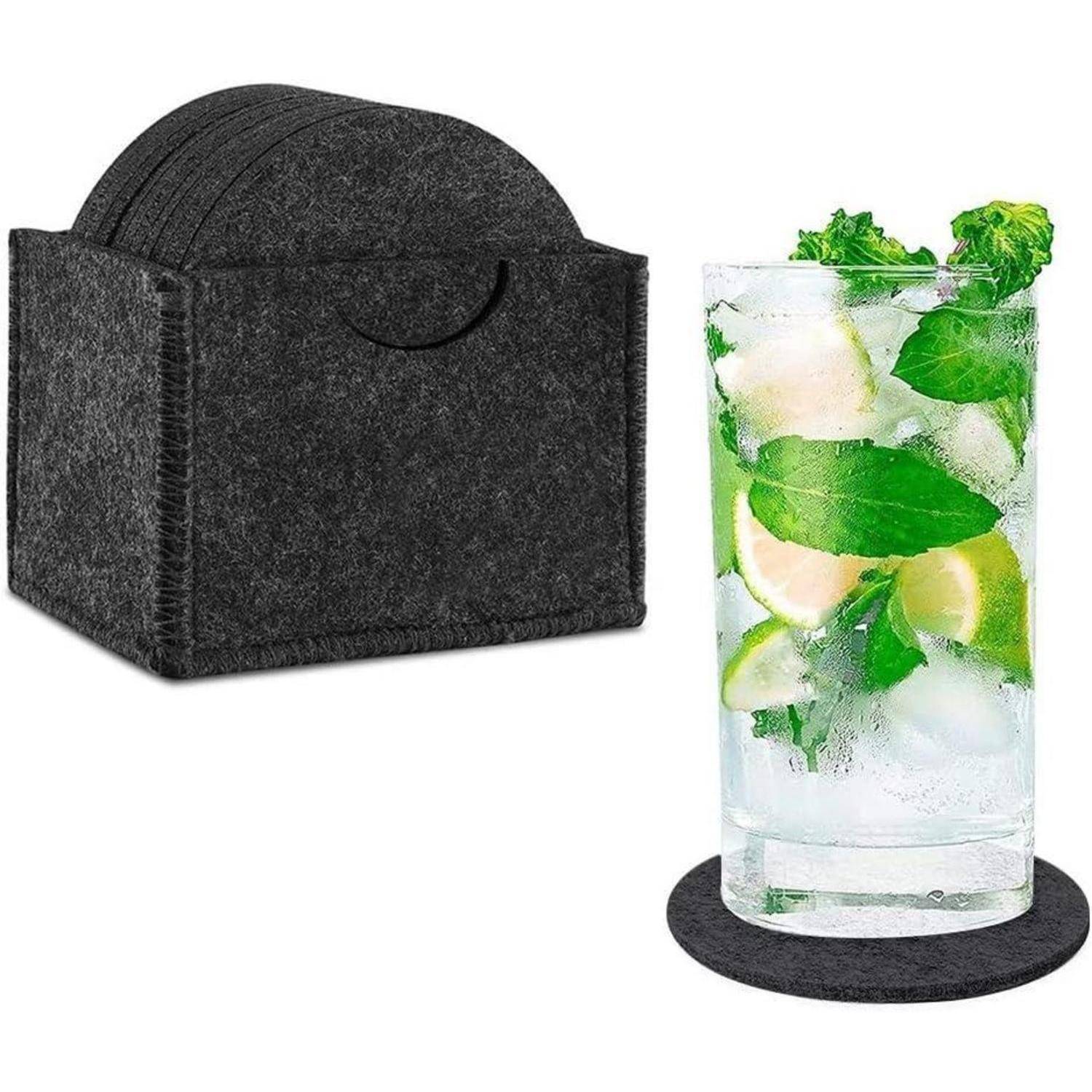 Ein Mojito-Glas mit Minzblättern und Limettenscheiben auf einem runden schwarzen Filzuntersetzer, neben einem Halter mit weiteren Untersetzern.