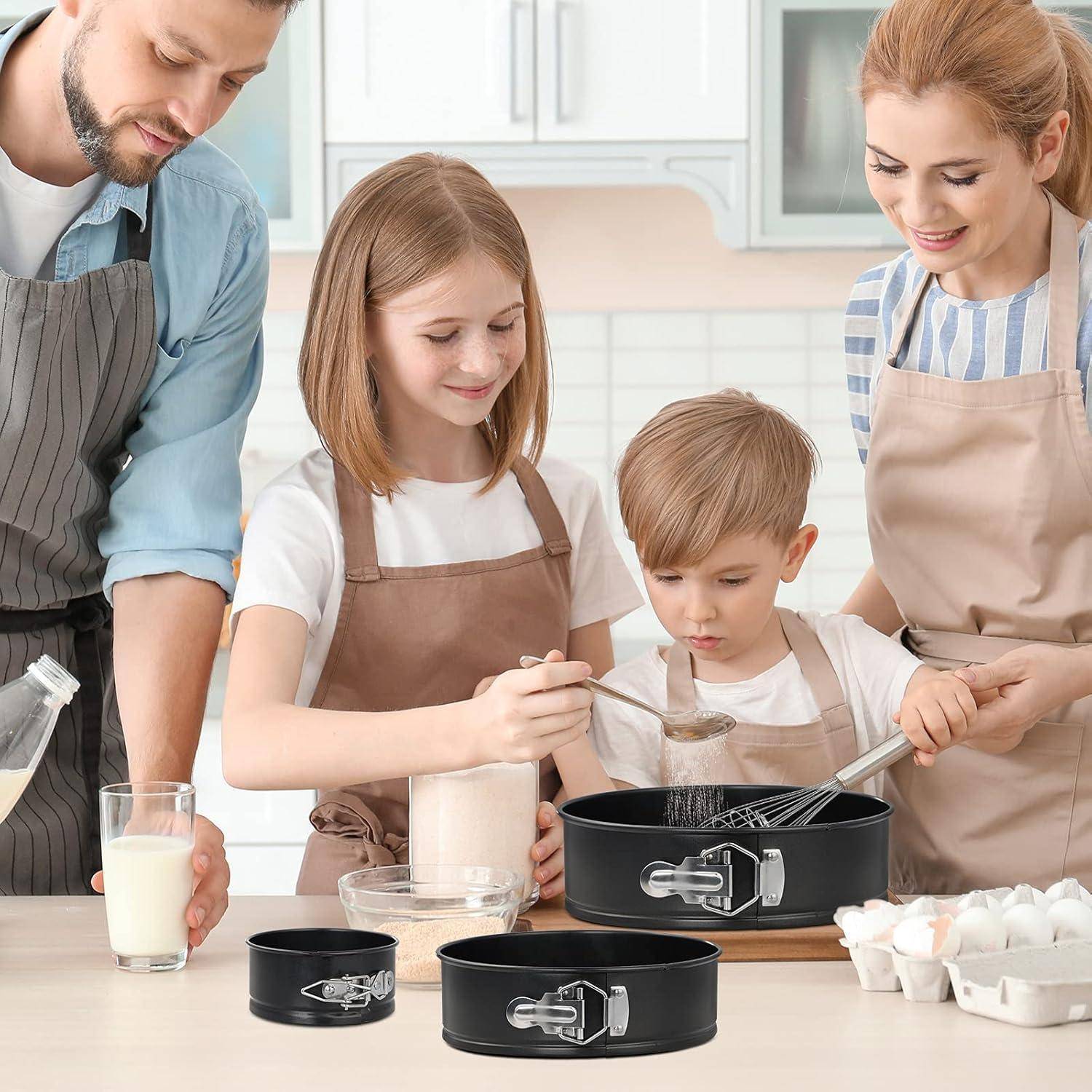 Eine vierköpfige Familie beim Backen in der Küche. Die Eltern helfen ihren Kindern, die Zutaten umrühren und abmessen. Backbleche liegen auf der Arbeitsplatte.