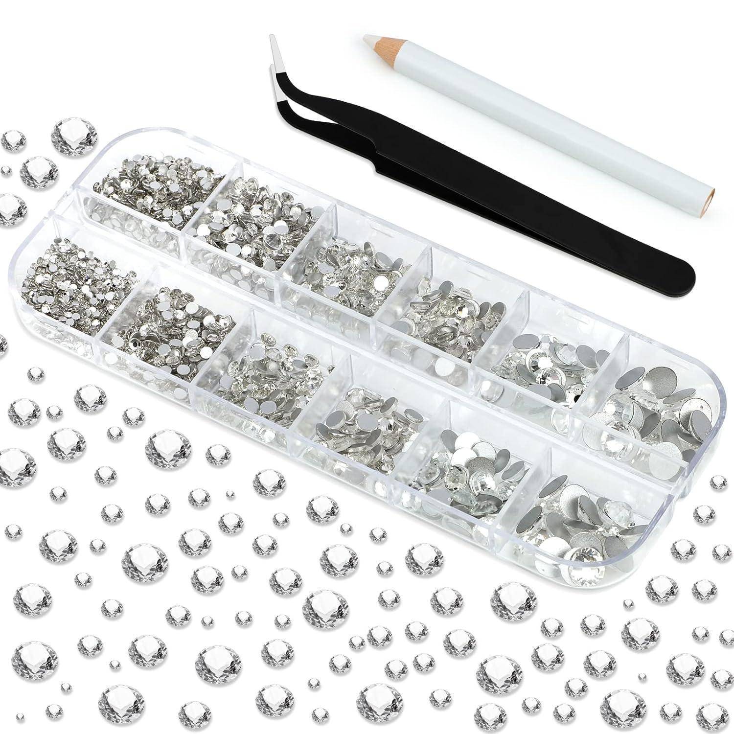 Ein Nail-Art-Set mit einer Vielzahl von klaren Strasssteinen in unterschiedlichen Größen, einer schwarzen Pinzette und einem weißen Bleistift zum Auftragen der Steine.