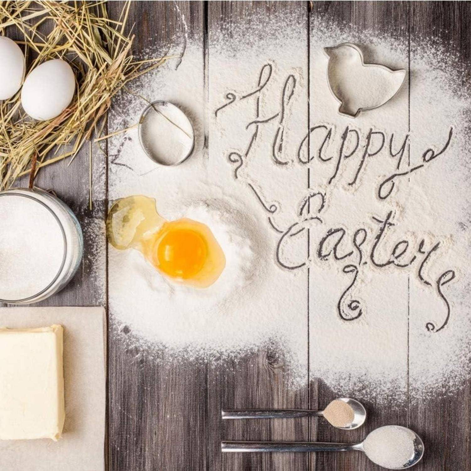 Eier, Mehl, Zucker und Butter auf einer Holzoberfläche, mit der Aufschrift 