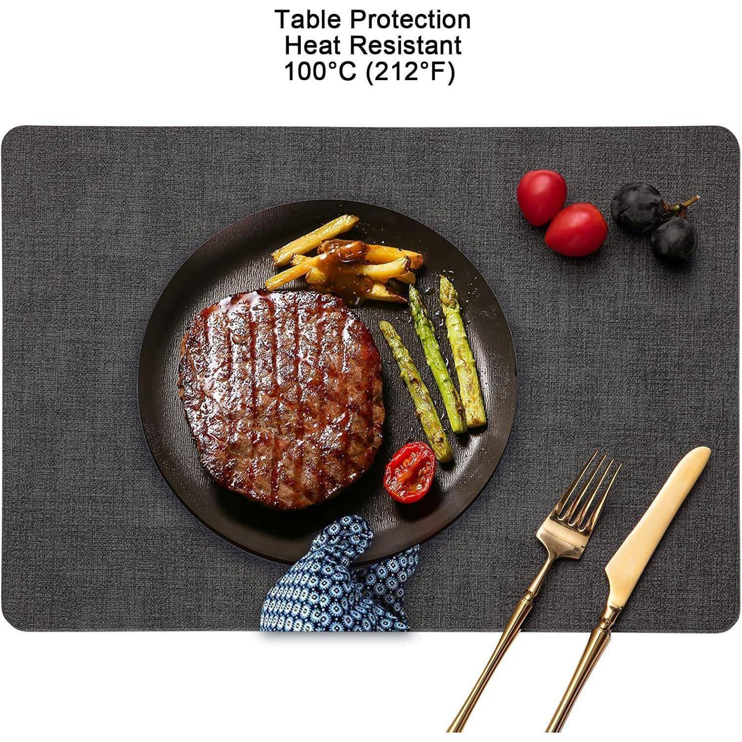Ein Teller mit einem gegrillten Steak, Spargel und Kartoffeln auf einem dunklen Platzdeckchen, begleitet von einer Gabel und einem Messer. Text oben: 'Tischschutz Hitzebeständig 100°C (212°F)'.