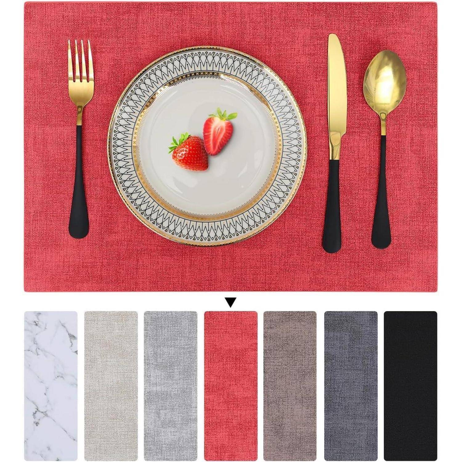 Eine Tischgedeck mit einem roten Platzset, Besteck mit schwarzen Griffen und goldener Beschichtung, einem dekorativen Teller mit zwei Erdbeeren. Darunter befinden sich Beispiele für weitere Platzset-Farben.