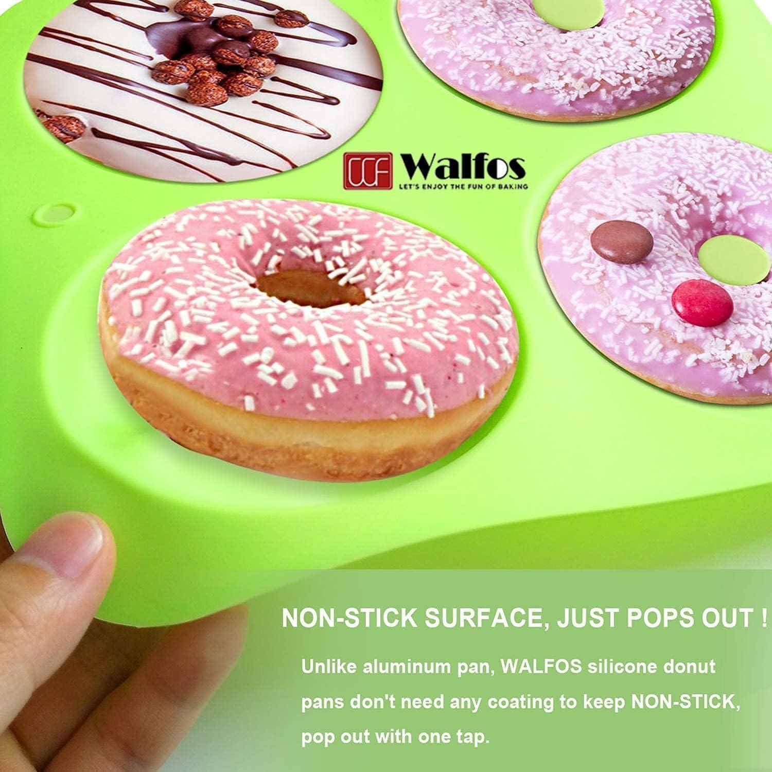 Eine Hand hält eine grüne Silikondonutform mit drei donutförmigen Vertiefungen. Ein rosa glasierter Donut mit Streusel liegt in einer der Vertiefungen.