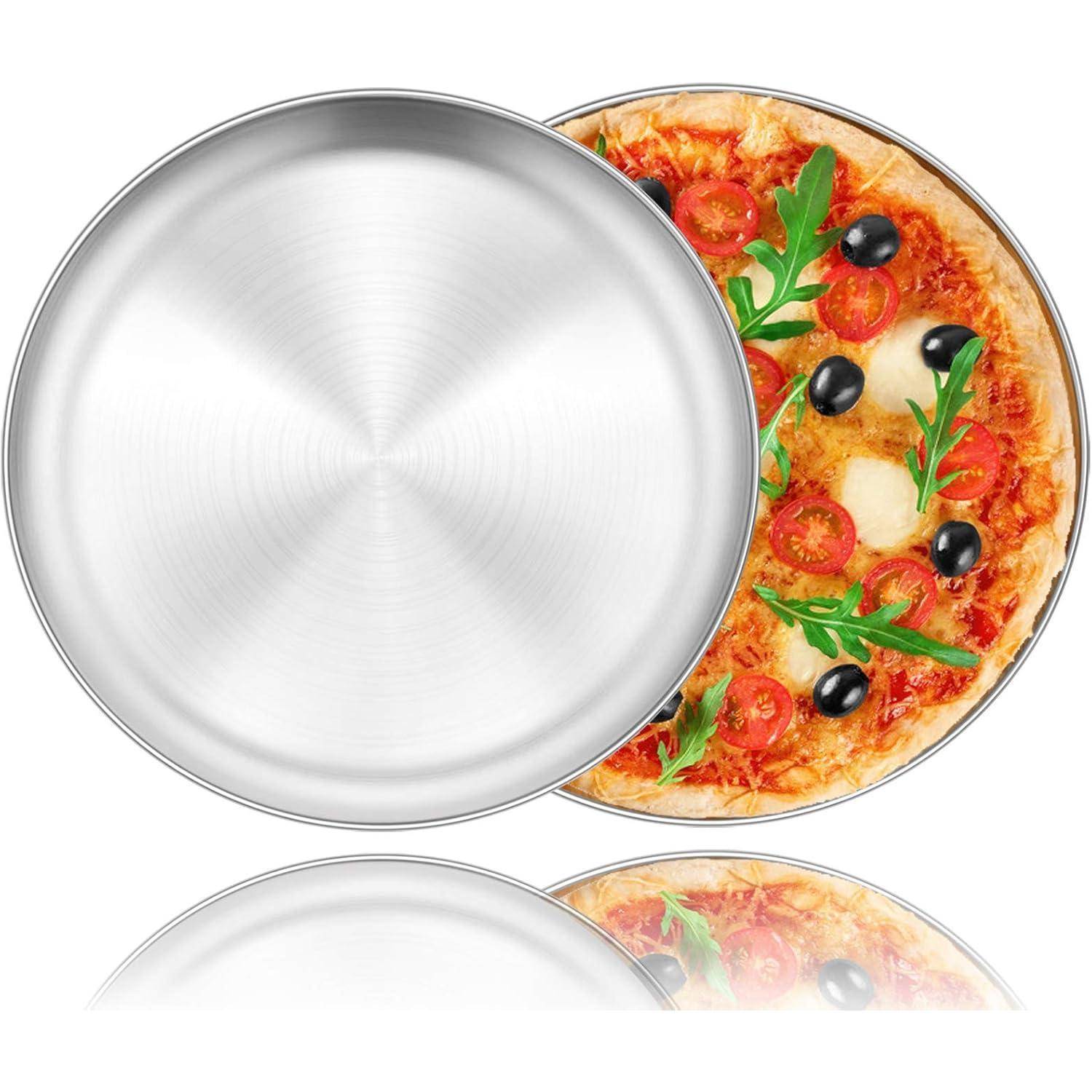 Eine offene Pizzaschachtel zeigt eine Pizza, belegt mit Tomaten, Oliven und Rucola, die teilweise von einem glänzenden, edelstahlfarbenen Deckel bedeckt ist.