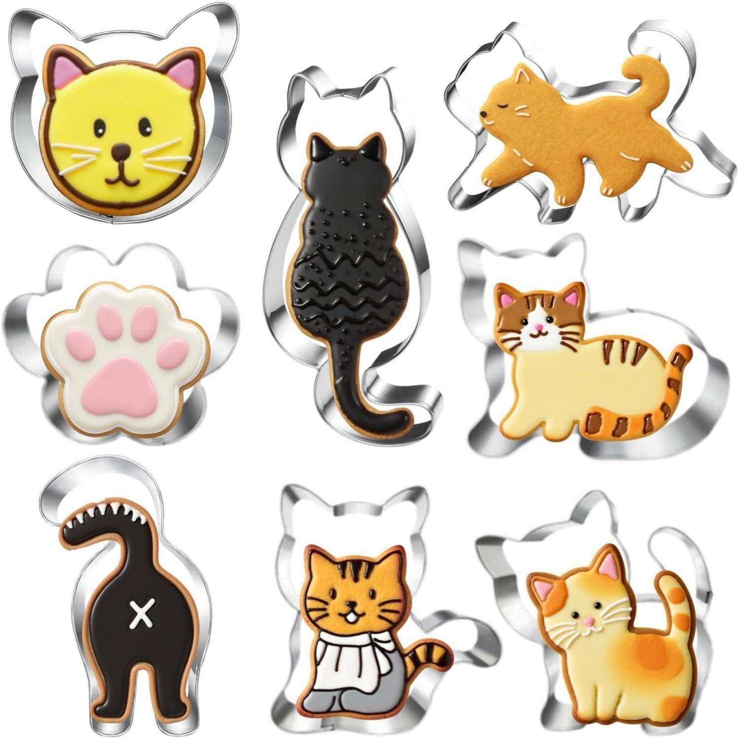 Eine Auswahl an katzenförmigen Keksen und Ausstechformen, darunter eine Pfötchen-Ausstecher, schwarze Katzen-Silhouette und verschiedene verspielt gestaltete Katzenformen.