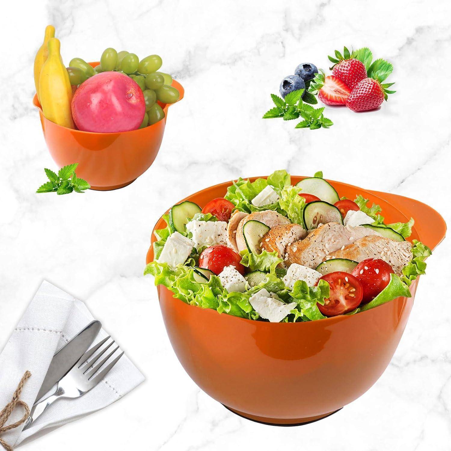 Eine Schüssel Salat mit Lattich, Gurke, Tomatenscheiben, Feta-Käse und gegrilltem Huhn in einer Marmor-Umgebung. Eine zweite Schüssel enthält Obst.