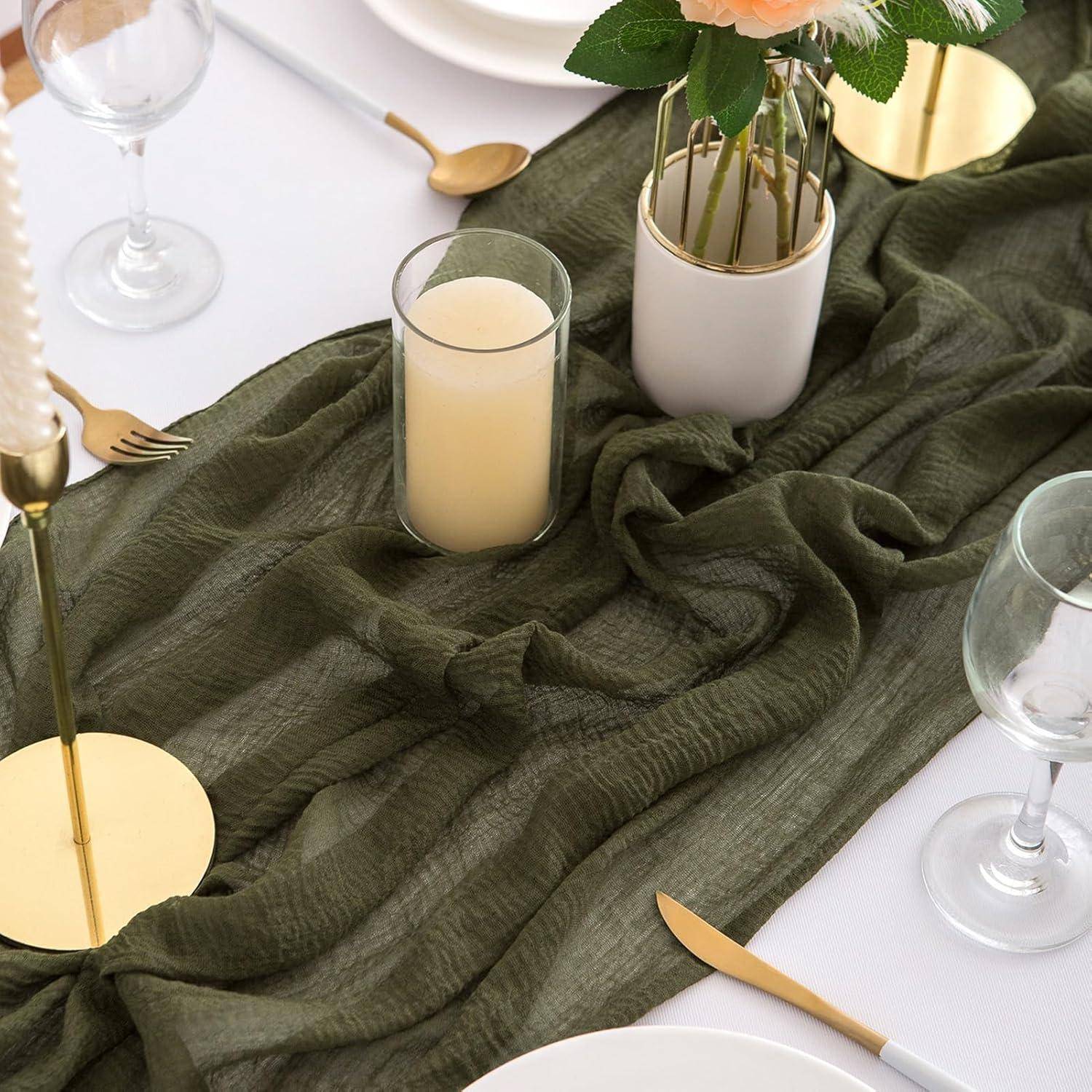 Elegante Tischdecke mit einem grünen Tuch, Kerzen, weißen Tellern, Besteck und einer Vase mit pfirsichfarbenen Rosen, was auf eine formelle Essensveranstaltung hindeutet.