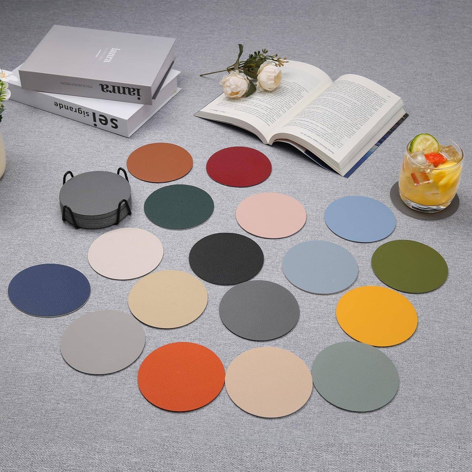 Eine Sammlung bunter runder Untersetzer in verschiedenen Farbtönen, die auf einem Tisch mit Büchern, weißen Blumen und einem Getränk in der Nähe angeordnet sind.