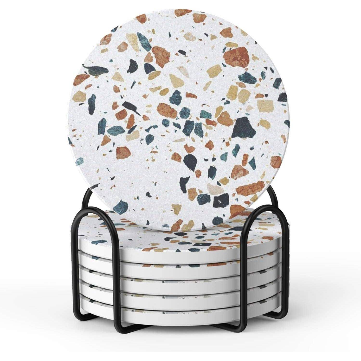 Set von runden Terrazzo-Untersetzer mit bunten Sprenkeln, gestapelt in einem schwarzen Metallhalter.