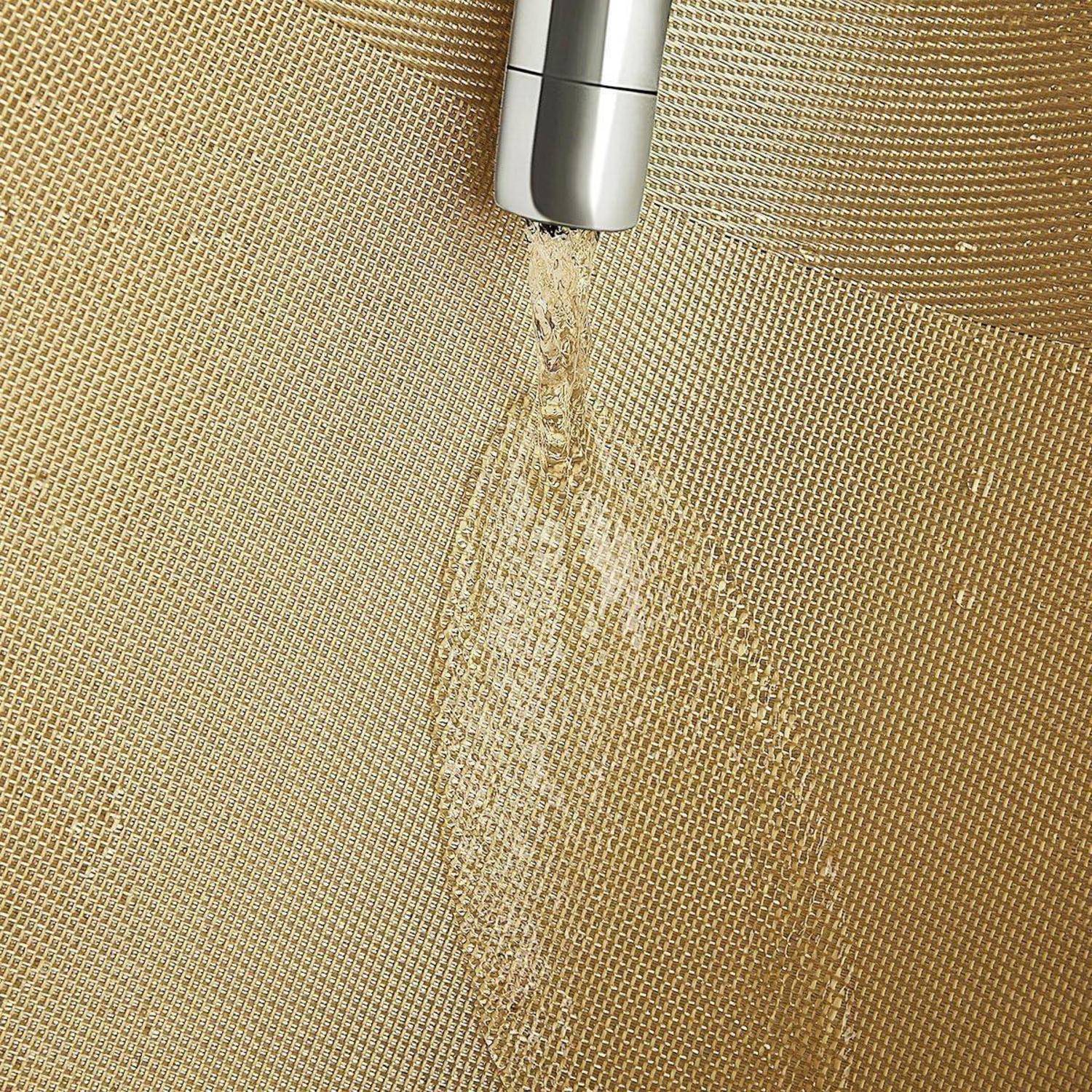 Wassersprühende Reinigung einer Goldgitteroberfläche, Nahaufnahme von Wassertropfen und Textur.