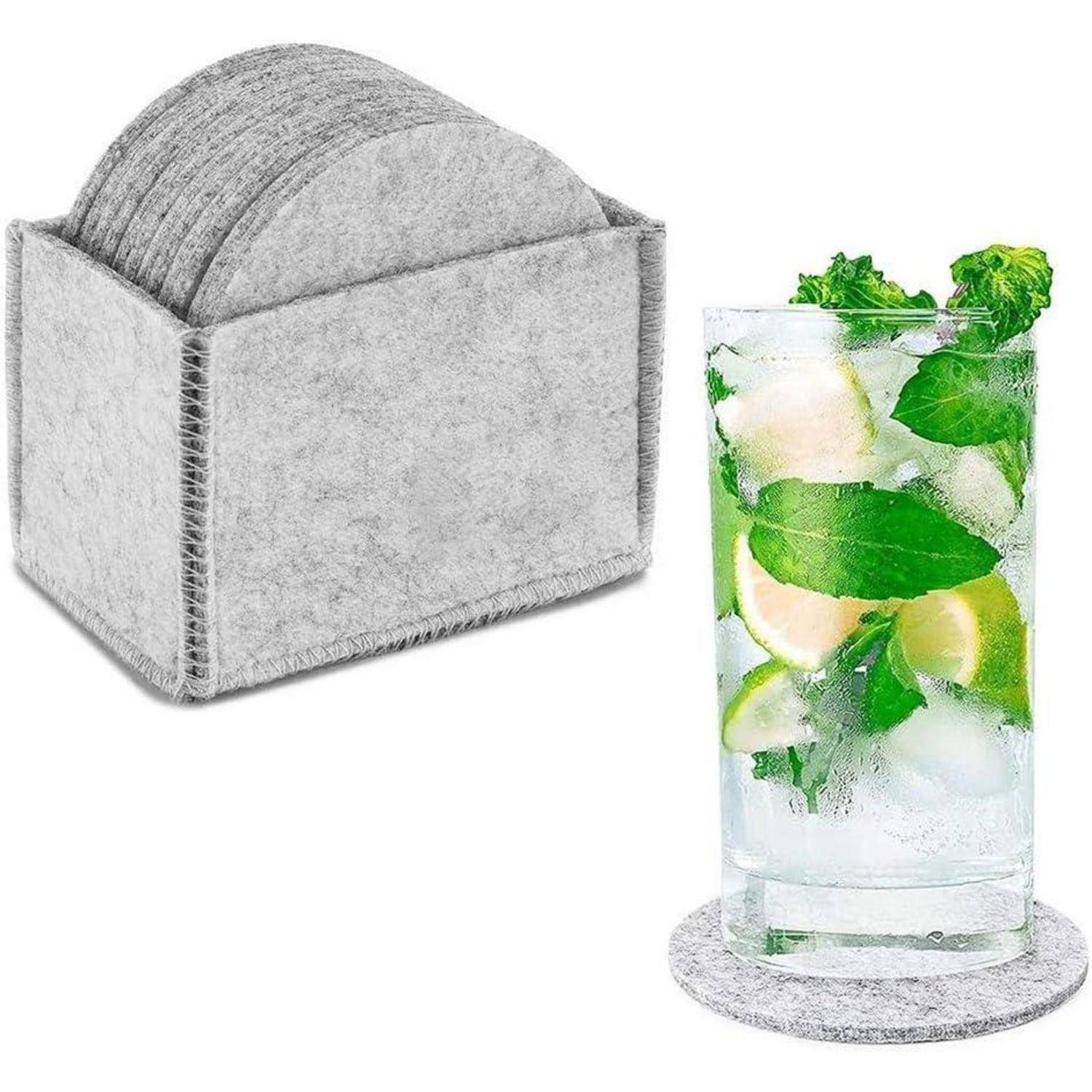 Ein Glas mit Minze- und Limettentrank auf einem runden Filzuntersetzer, neben einem Satz ähnlicher Untersetzer in einem Halter.