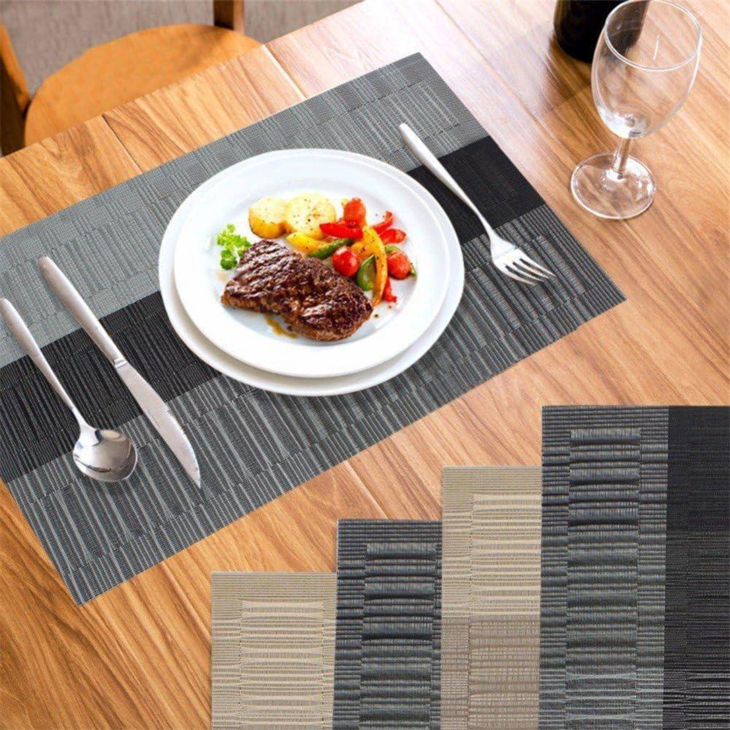 Teller mit Steak, Gemüse und Kartoffel auf einem Tischset; Gabel und Messer liegen daneben. Ein Weinglas steht in der Nähe auf einem Holztisch.