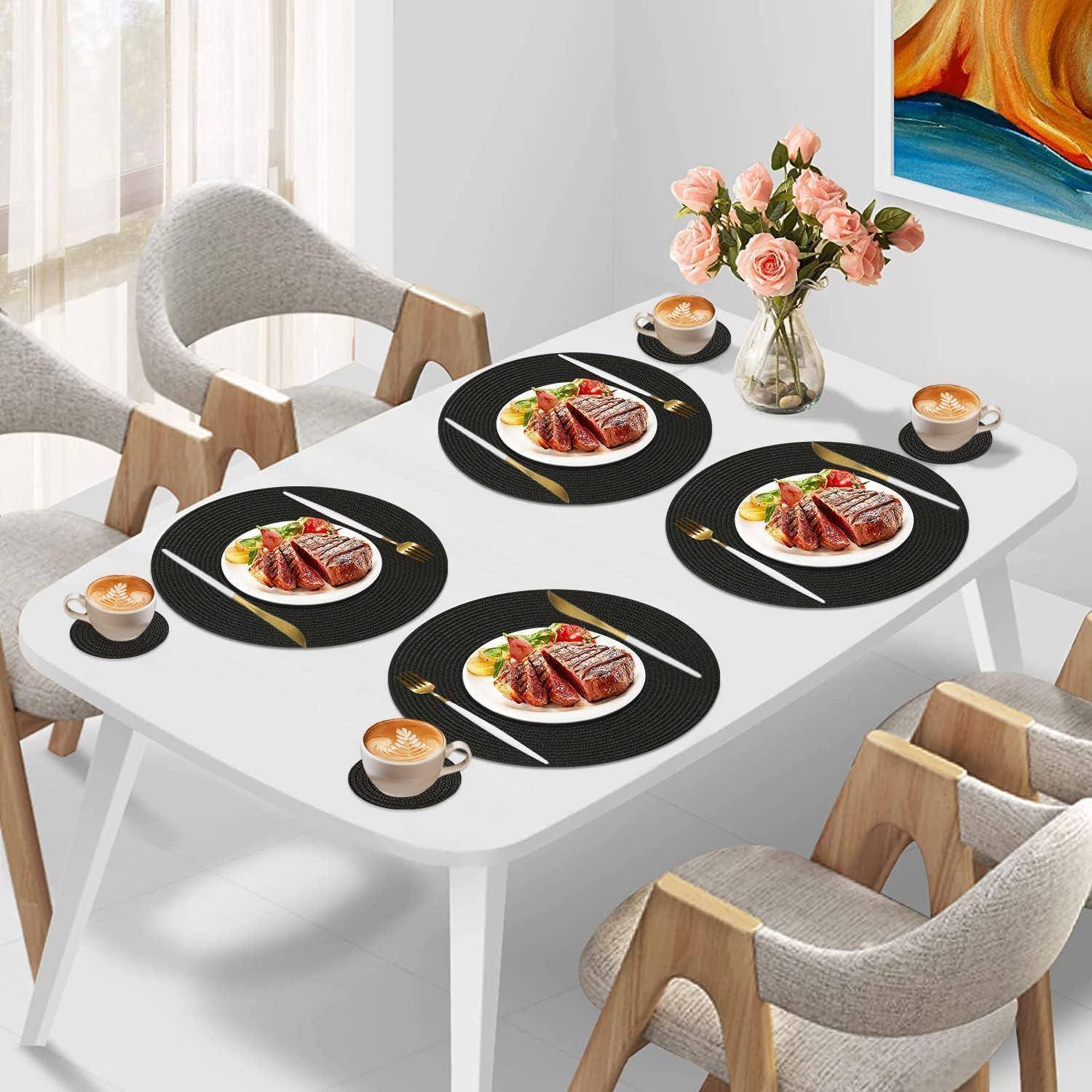 Ein Esstisch für vier Personen gedeckt mit Tellern mit Steak, Gemüse und Kaffeetassen. Eine Vase mit rosa Blumen steht in der Mitte.
