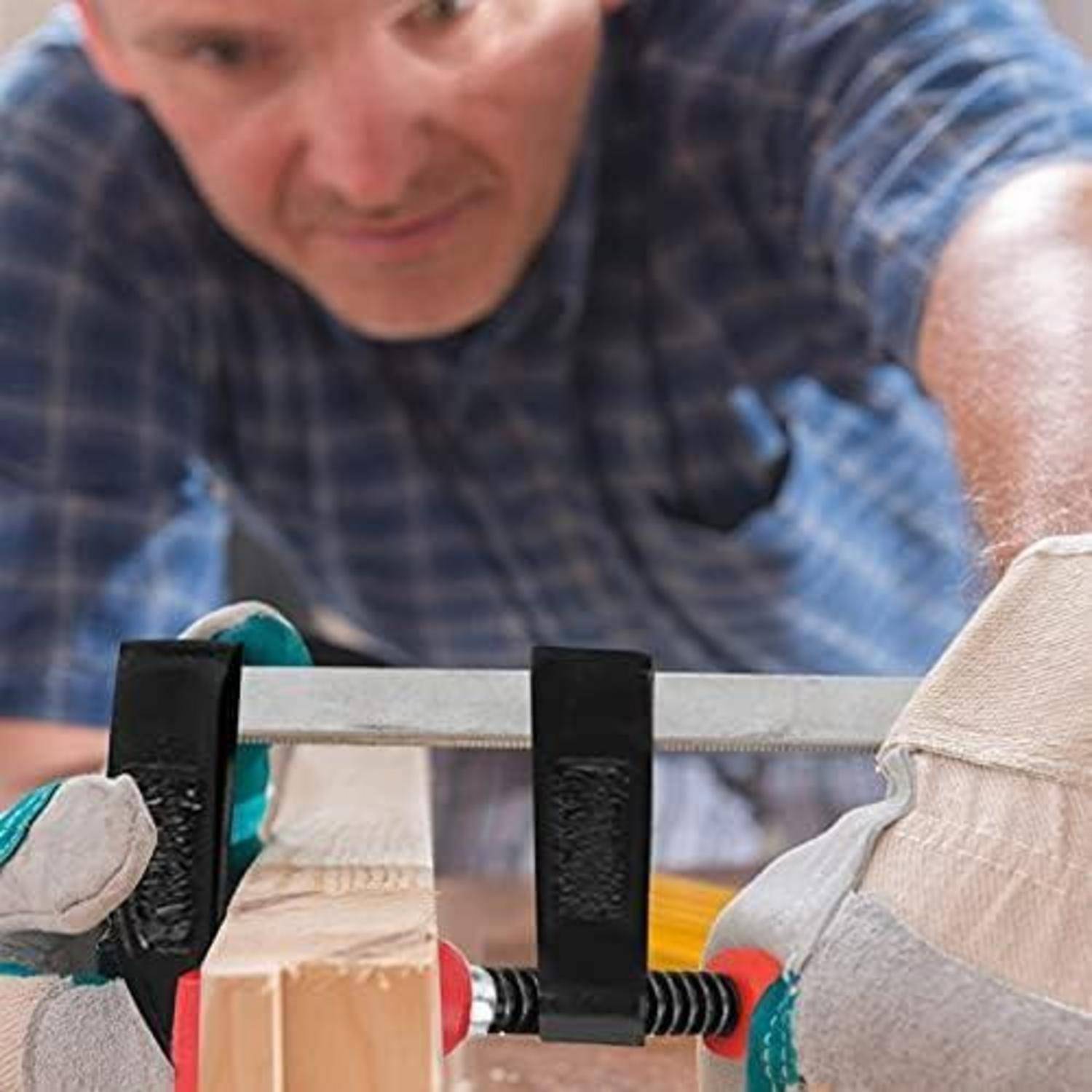 Eine Person in einer Werkstatt konzentriert sich darauf, ein Holzbrett mit einer Handsäge zu sägen. Das Bild betont Präzision und handwerkliches Geschick.
