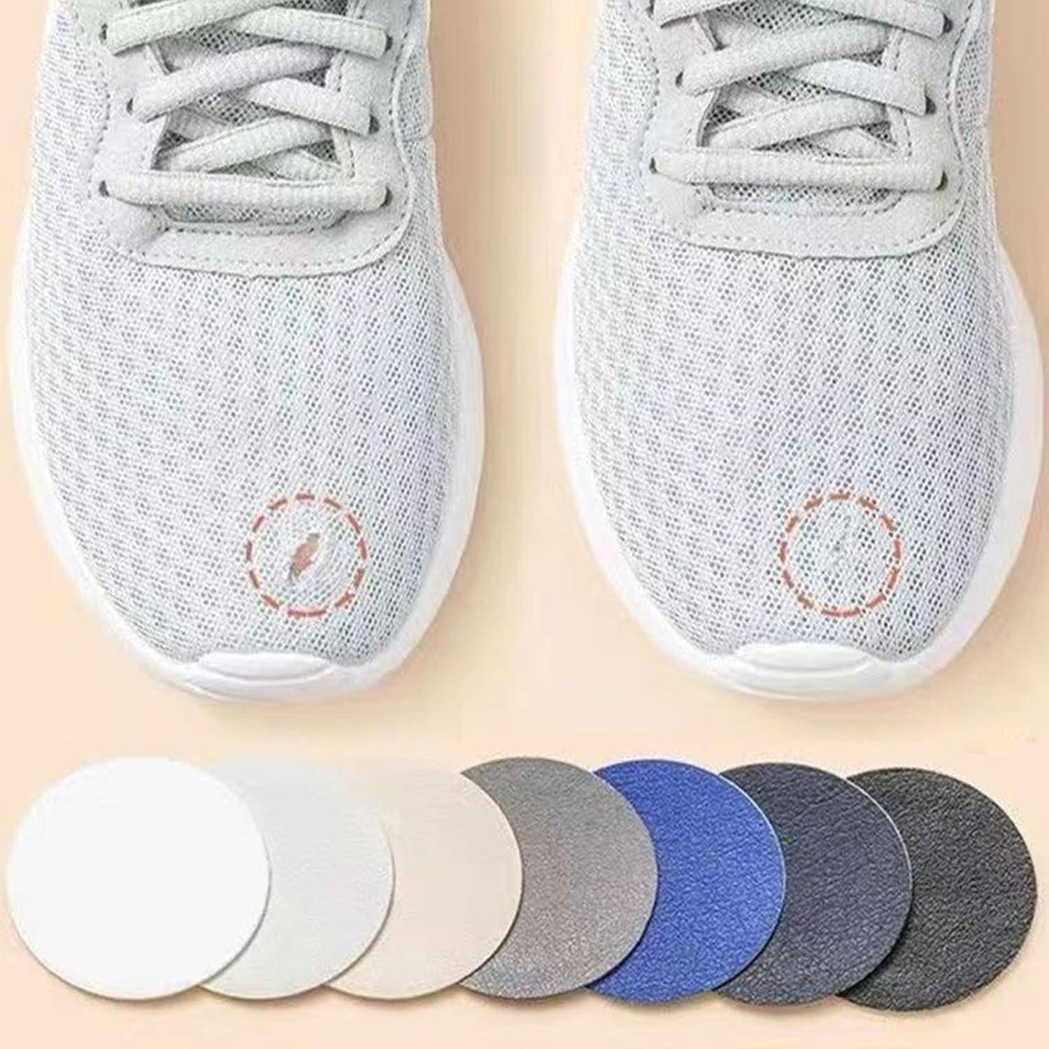 Graue Turnschuhe mit sichtbaren Gebrauchsspuren und abnehmbaren Patches. Darunter sieben kreisförmige Stoffpatches in verschiedenen Farben zur Individualisierung.