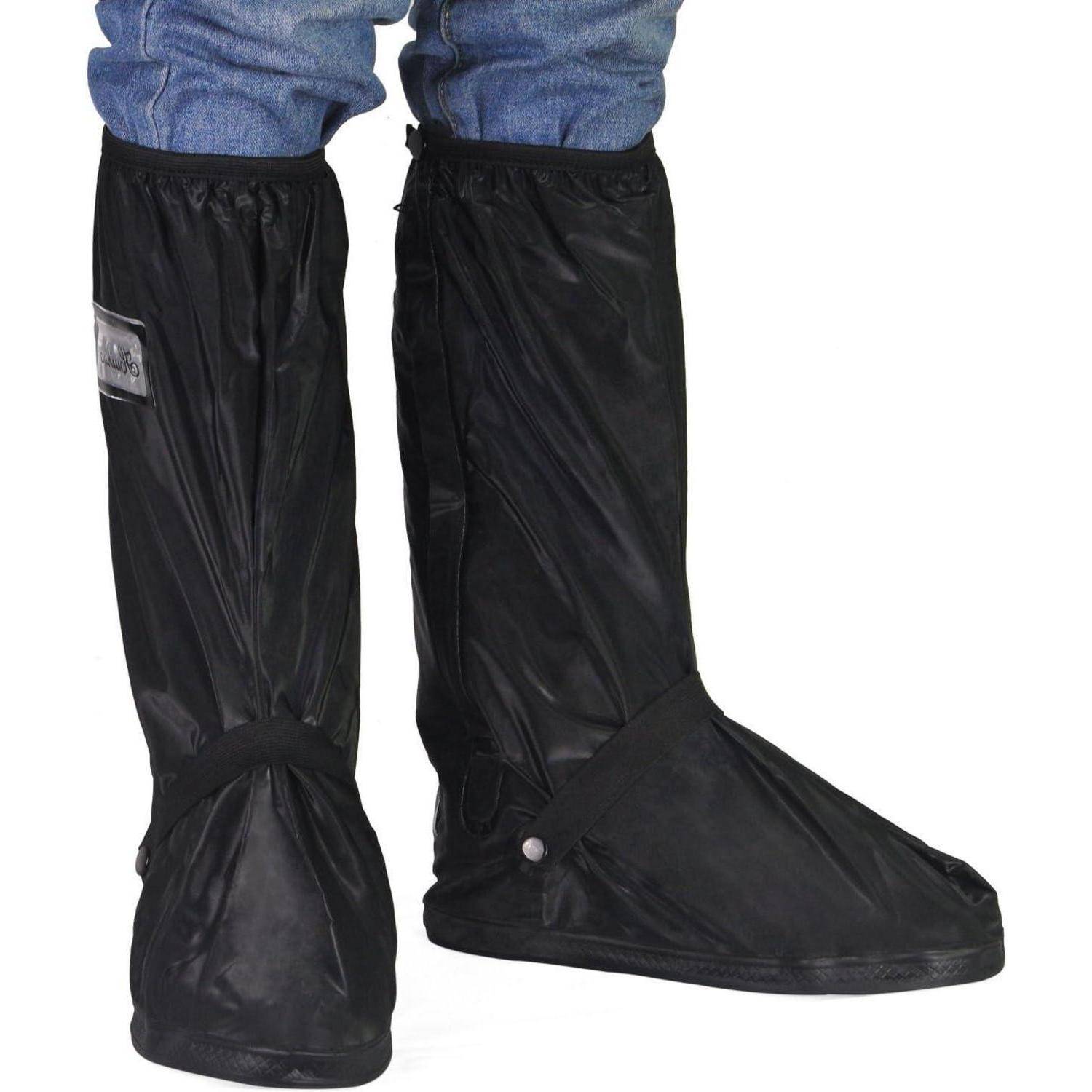 Eine Person trägt schwarze wasserdichte Schuhüberzieher über blauen Jeans. Die Überzieher reichen bis zur Wade und wirken robust, verwendet zum Schutz vor Regen.