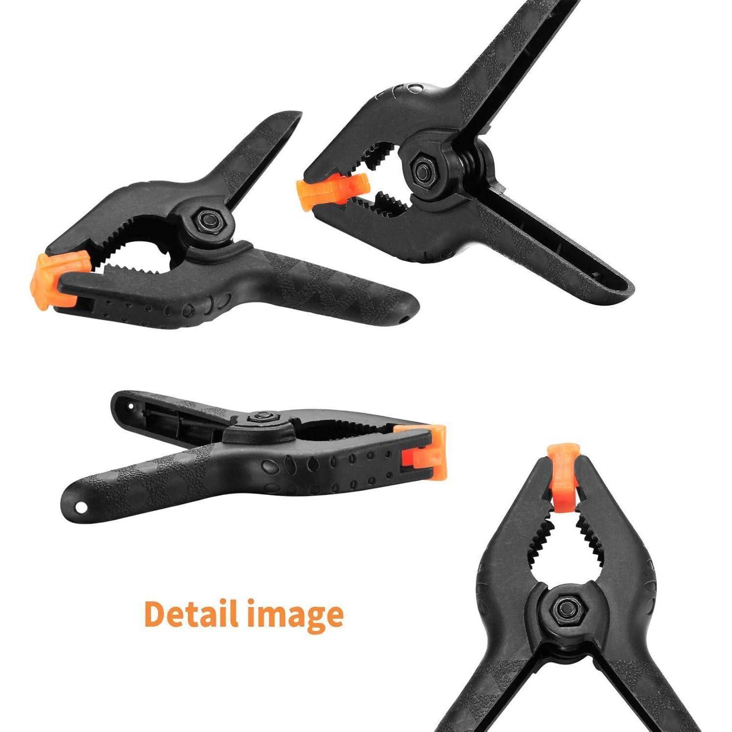 Drei schwarze Kunststoffklemmen mit orangefarbenen Spitzen, in verschiedenen Winkeln positioniert. Text liest sich 