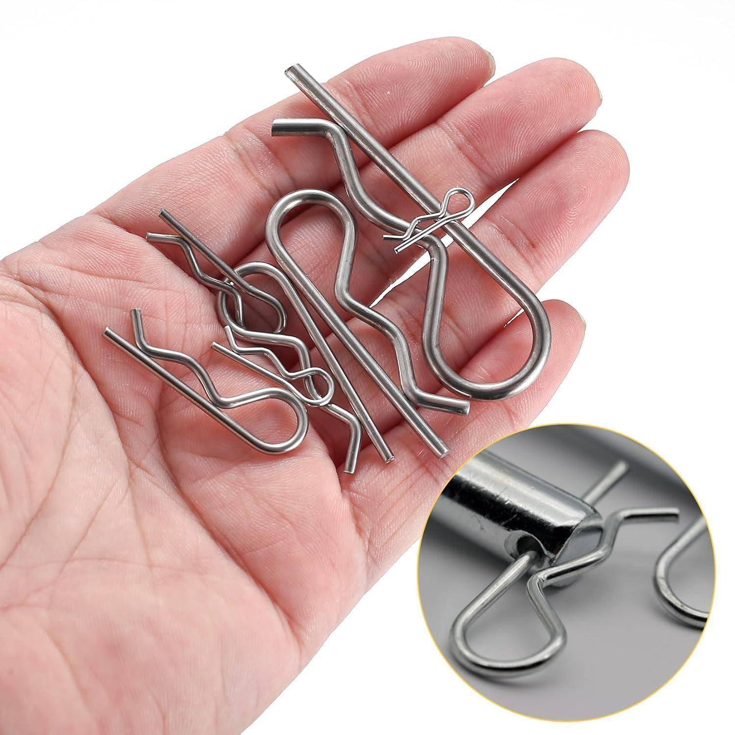 Eine Hand hält mehrere Metallsicherungsclips (R-Clips) in verschiedenen Größen, die üblicherweise zum Sichern von Stiften und Wellen verwendet werden. Ein Einsatzbild zeigt eine Detailaufnahme eines Clips in Verwendung.