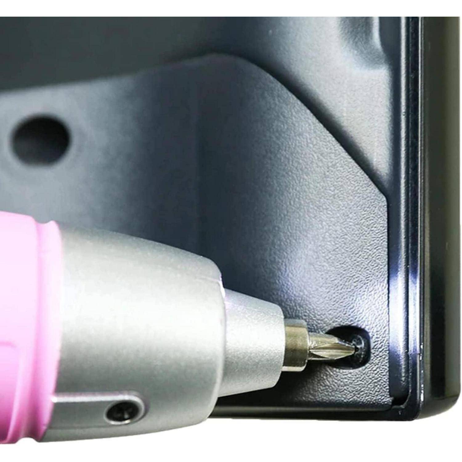 Eine Nahaufnahme eines Schraubenziehers mit einem pinken Griff, der eine Schraube auf einer schwarzen Metalloberfläche festzieht.