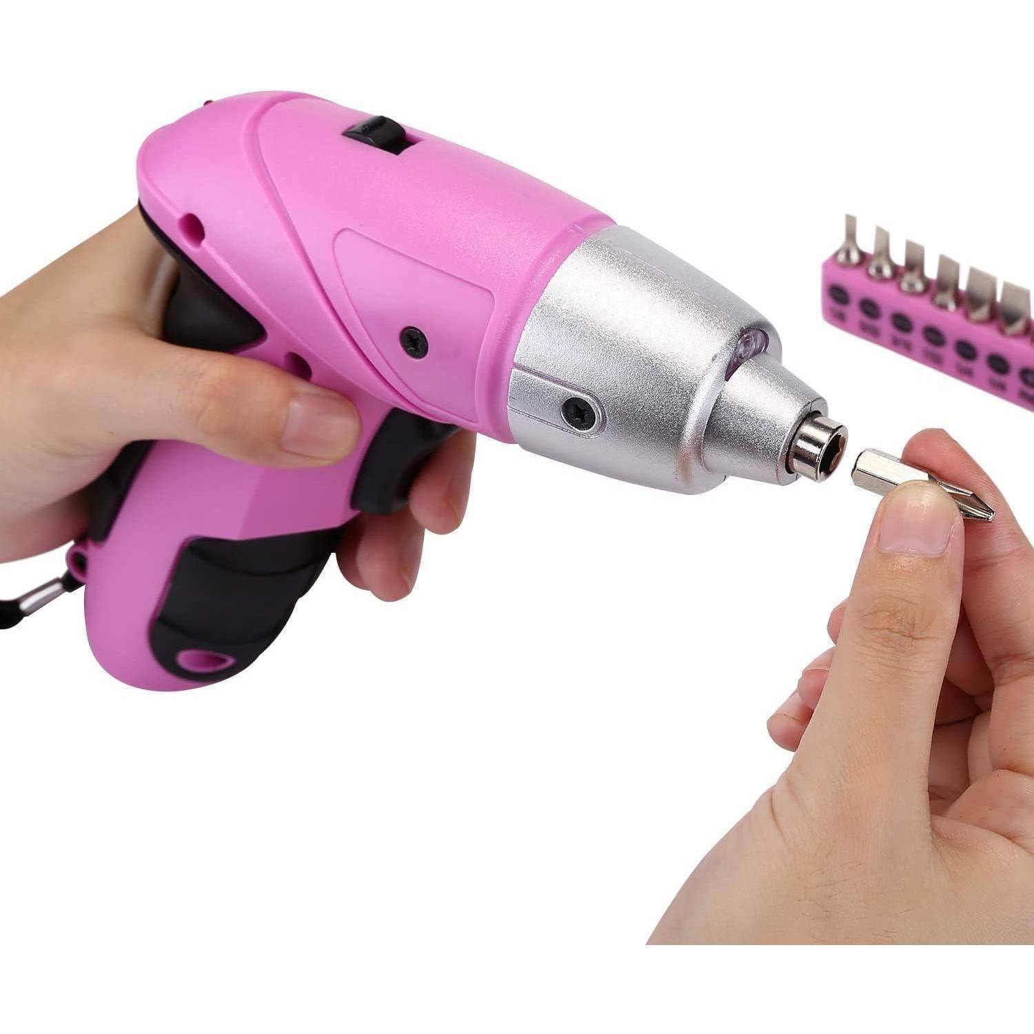Hände, die einen pinken kabellosen Akkuschrauber mit einem Bohrer halten, daneben eine Reihe verschiedener Bohraufsätze.