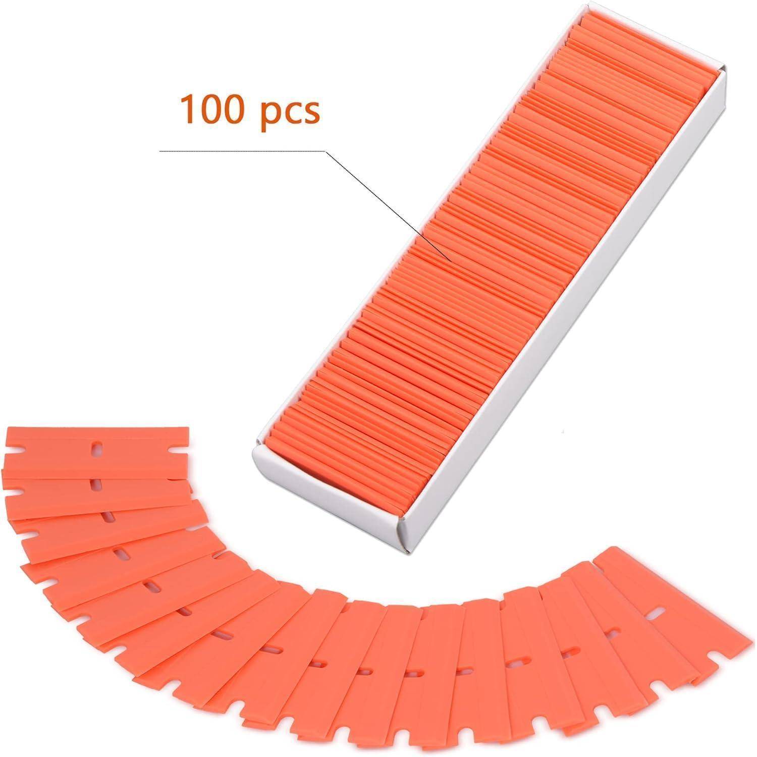 Orange Plastik-Rasierklingen, 100 Stück in einer weißen Box verpackt, teilweise für die Präsentation aufgefächert.