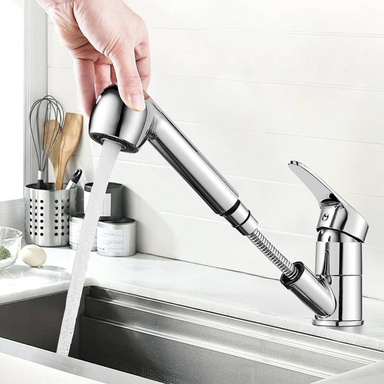 Eine Hand zieht eine moderne, verchromte Küchenarmatur-Brause heraus, während Wasser in ein Waschbecken fließt. Im Hintergrund sind Küchenutensilien sichtbar.