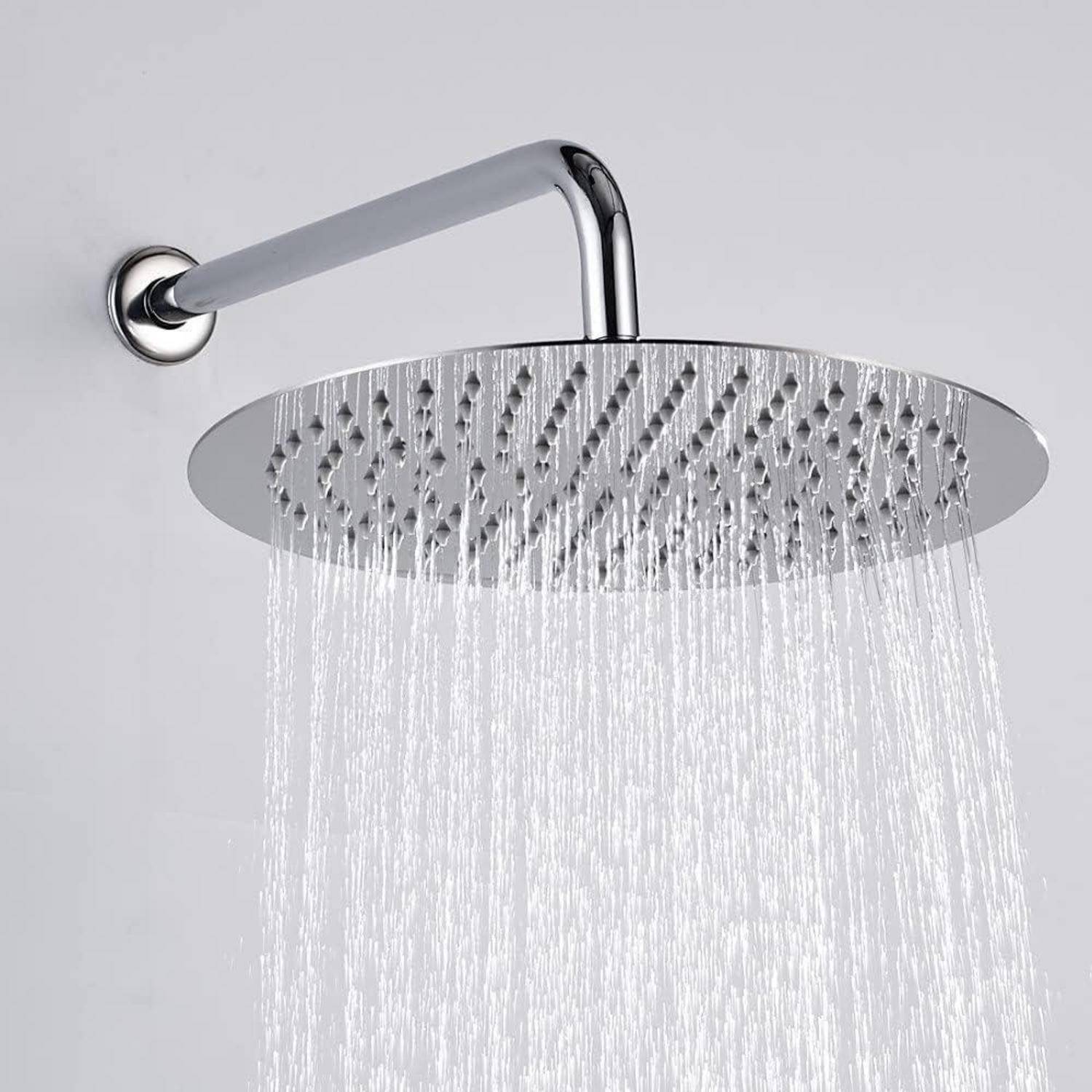 Eine Chrom-Regendusche gibt einen gleichmäßigen Wasserstrahl ab. Der Duschkopf ist an der Wand befestigt und verfügt über zahlreiche Wasserdüsen.