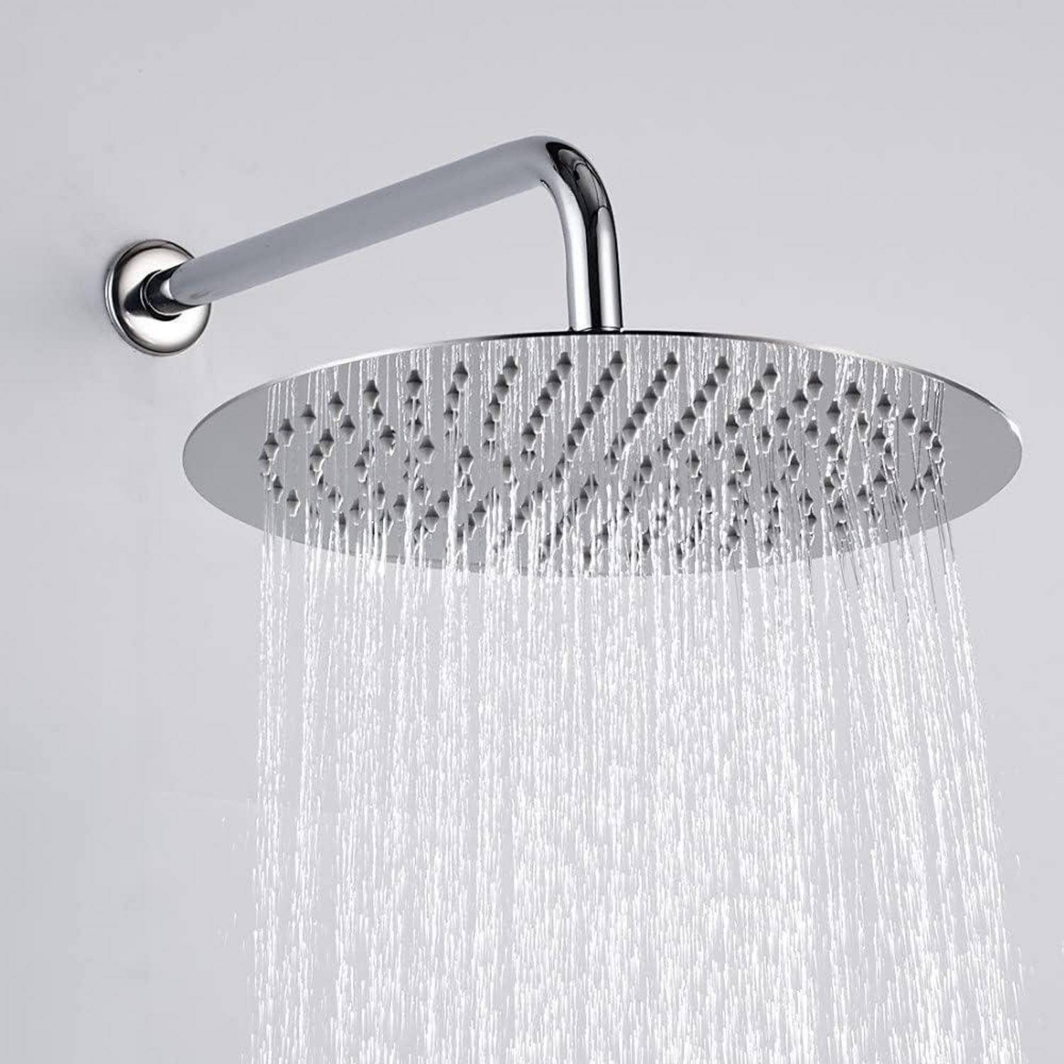Ein moderner Chrom-Duschkopf, der einen gleichmäßigen Wasserstrahl abgibt und an einer weißen Wand montiert ist und eine luxuriöse Badezerfahrung andeutet.