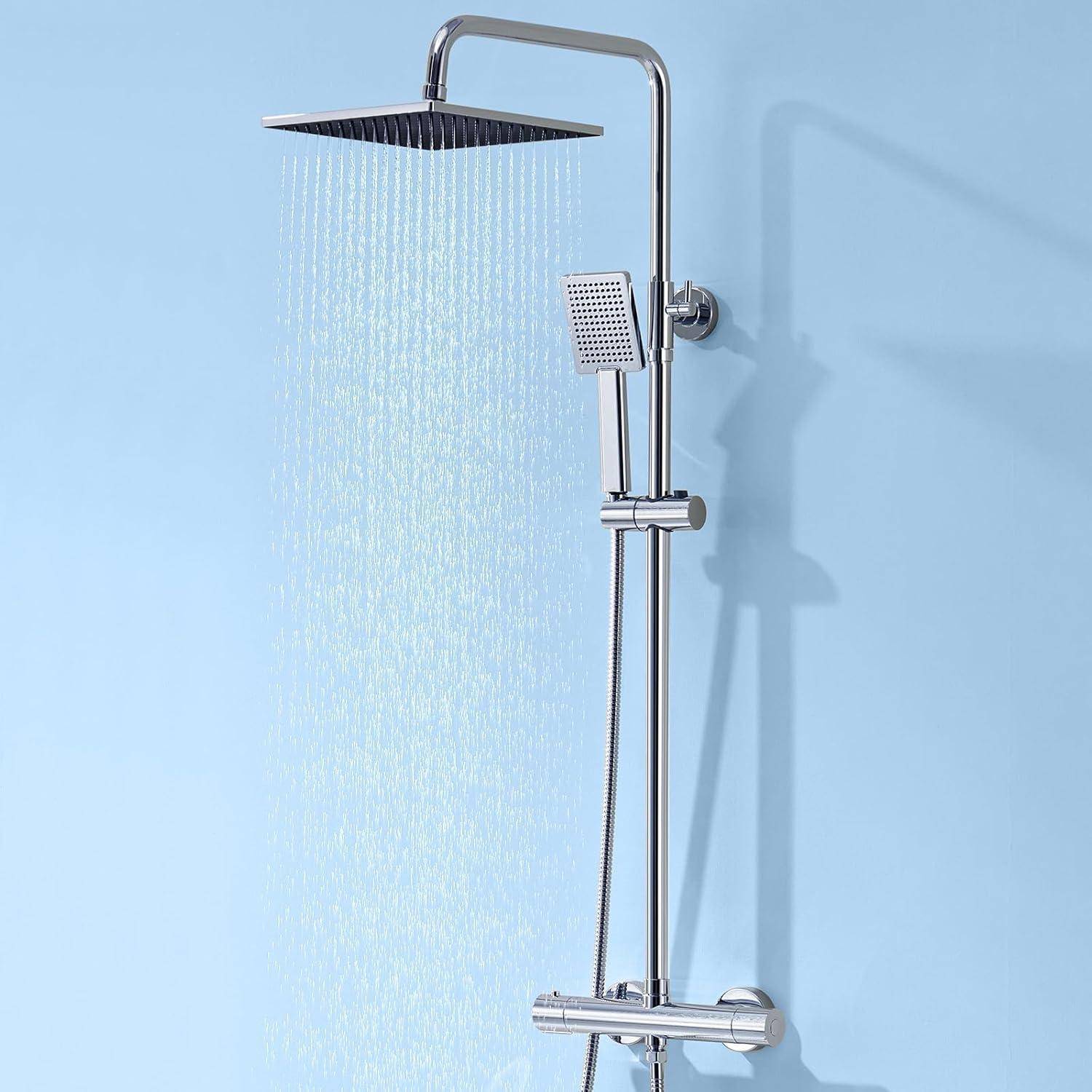 Ein modernes Duscharmatursystem mit einem quadratischen Duschkopf von oben und einer Handbrause, an einer blauen Wand montiert, die Wasserstrahlen abgibt.