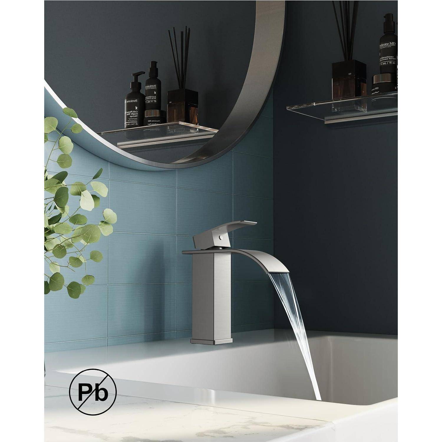 Ein modernes Waschbecken mit einem schlanken silbernen Wasserhahn, umgeben von blauen Fliesen und einem runden Spiegel. Grünpflanzen verleihen einen Hauch von Natur.