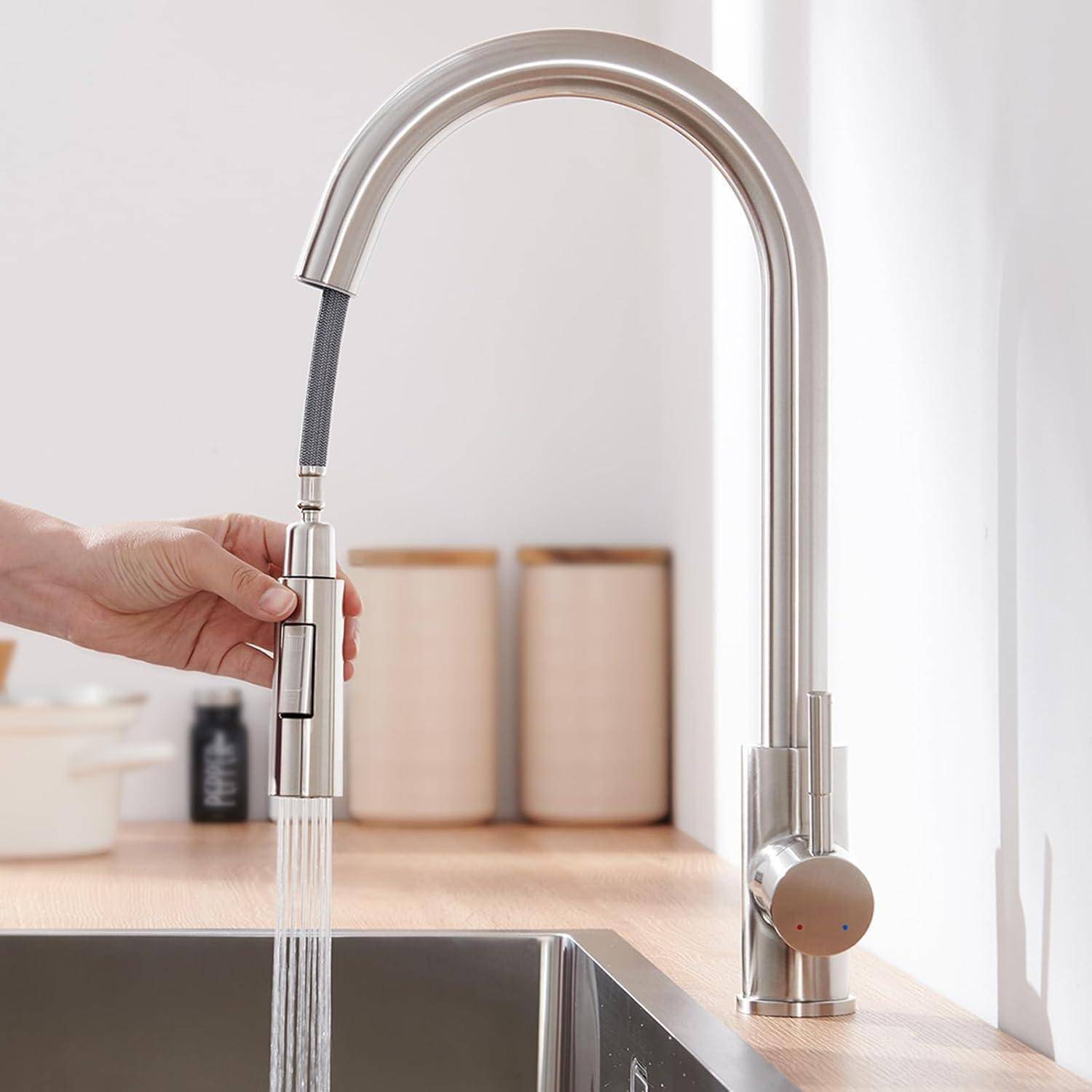 Eine Hand justiert einen modernen Wasserhahn aus Edelstahl, aus dem Wasser in ein Waschbecken fließt, vor dem Hintergrund einer aufgeräumten Arbeitsfläche.