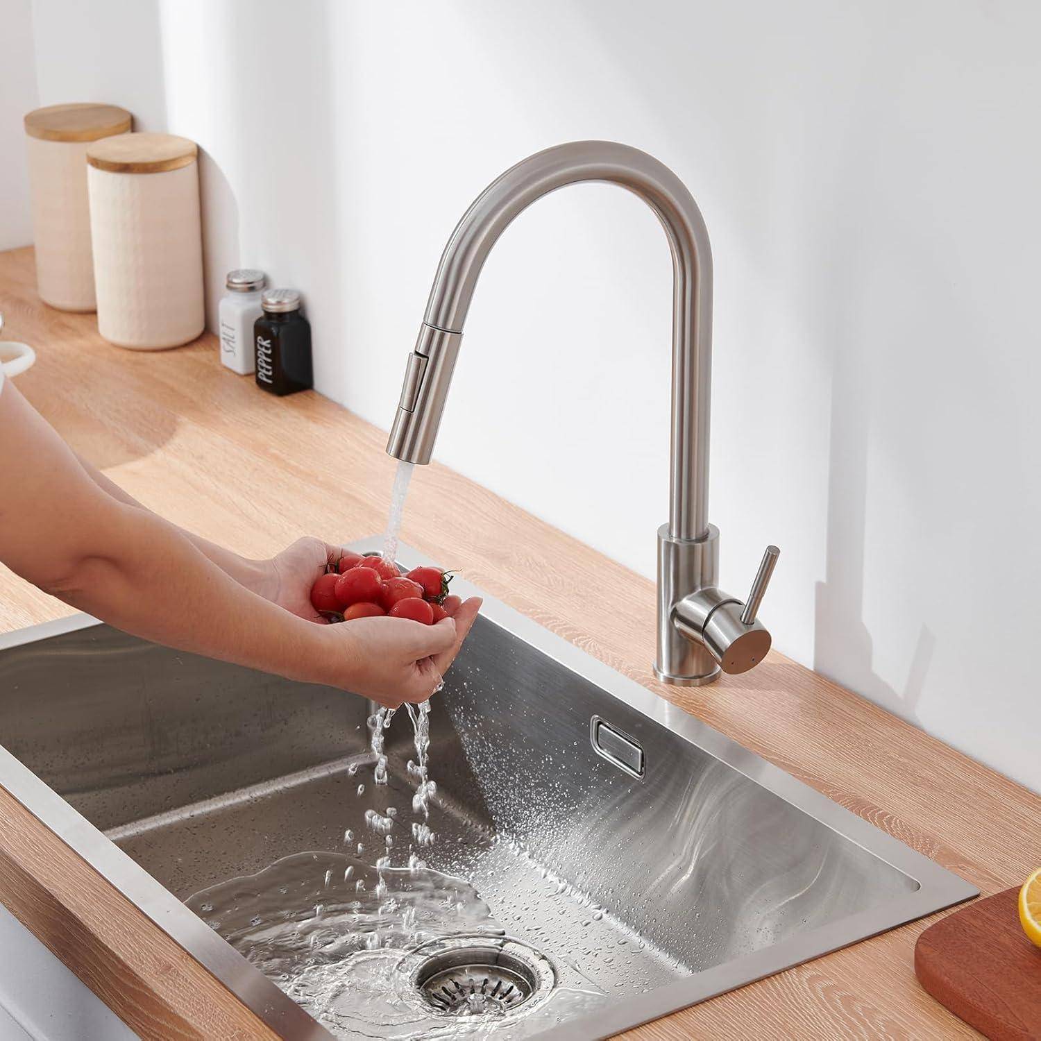 Eine Person wäscht rote Radieschen unter einem Edelstahl-Wasserhahn in der Küche. Das Waschbecken und die Arbeitsplatte sind sauber und minimalistisch gestaltet, mit Gegenständen wie einem Gewürzglas und Küchenutensilien im Hintergrund.