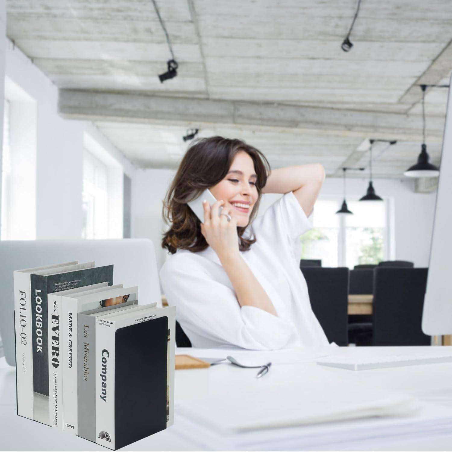 Eine Person telefoniert und lächelt, während sie an einem Schreibtisch in einem modernen, hellen Büro sitzt, mit Büchern, die mit 