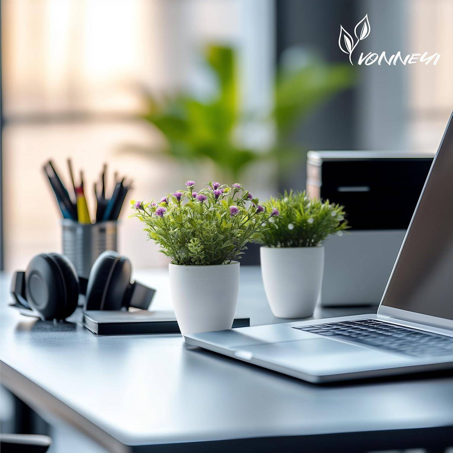 Ein modernes Schreibtisch-Setup mit einem Laptop, Kopfhörern, Zimmerpflanzen und Schreibwaren. Ein unscharfer Hintergrund deutet auf einen ruhigen, produktiven Arbeitsbereich hin.