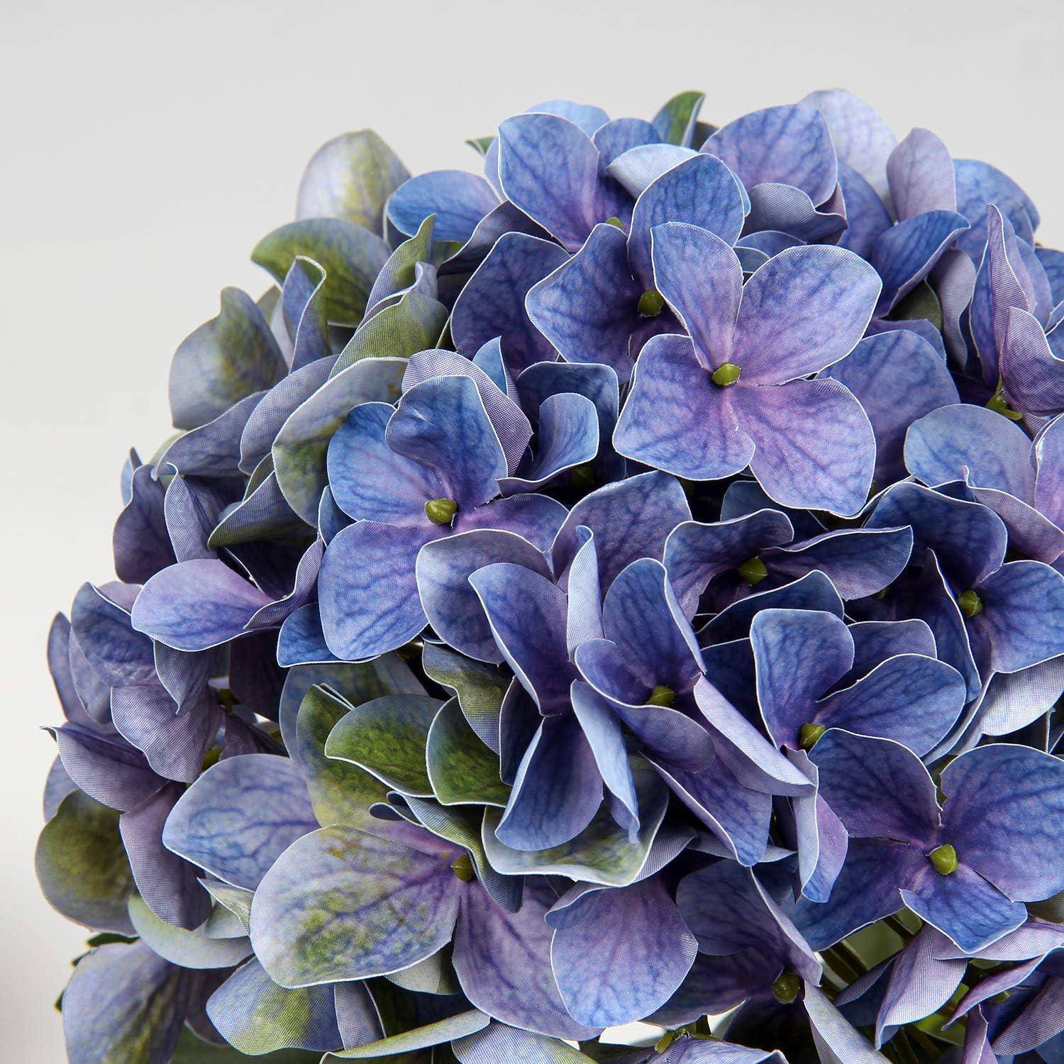 Ein Strauß leuchtend violetter und blauer Hortensienblüten mit zarten Blütenblättern und grünlich getönten Blättern.