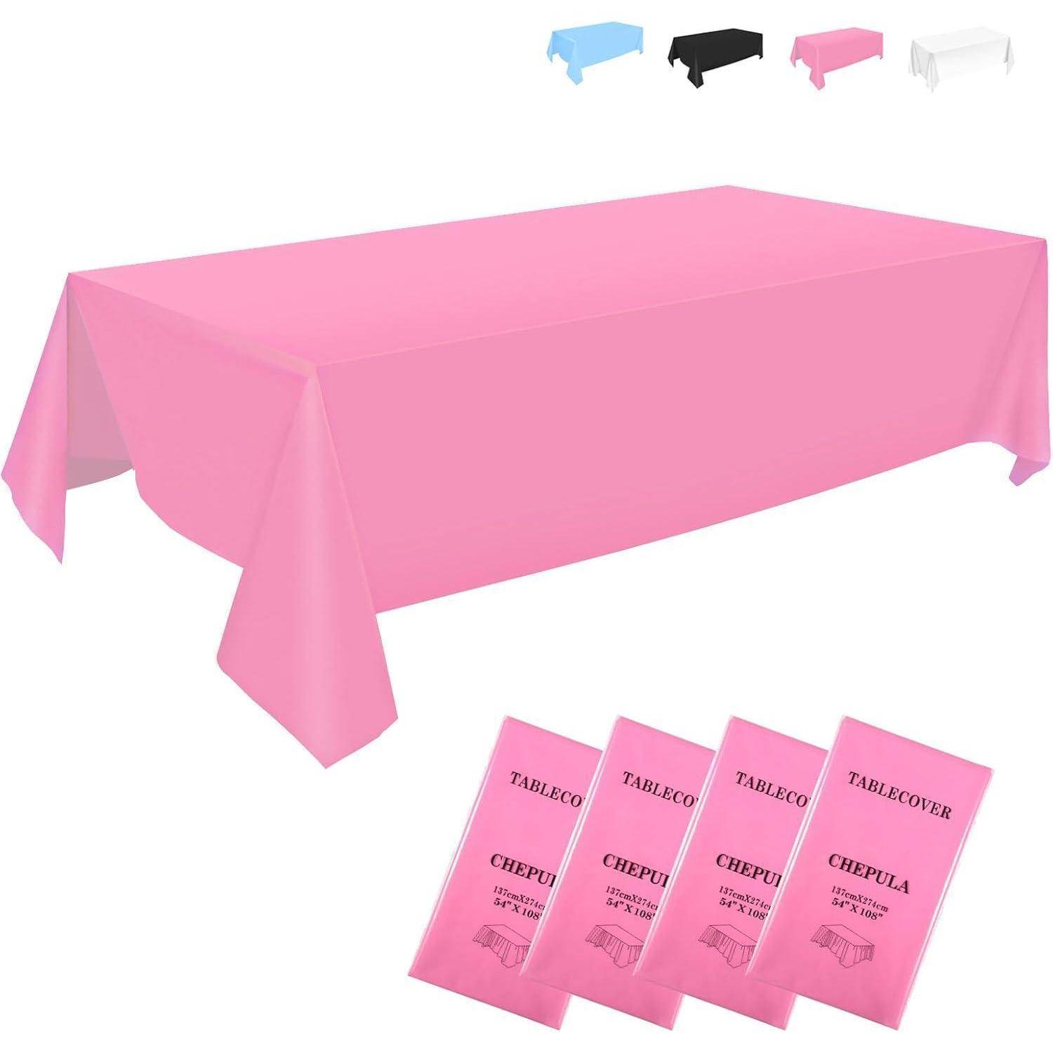Eine rosa rechteckige Tischdecke mit gefalteter Verpackung in der gleichen Farbe. Zusätzliche Bezüge in Blau, Schwarz und Weiß sind sichtbar.