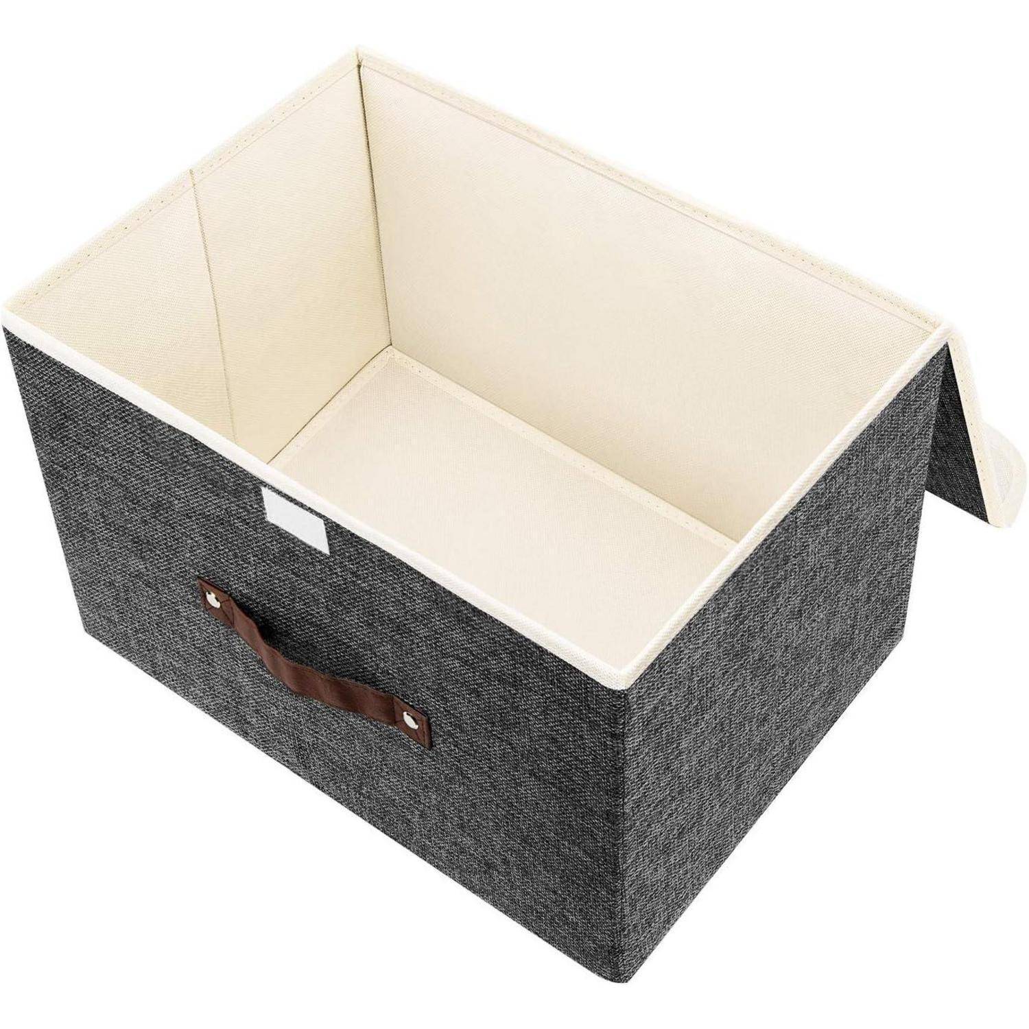 Eine dunkelgraue Stoffaufbewahrungsbox, oben offen, mit einem braunen Griff an der Seite, auf einem hellen Hintergrund platziert.