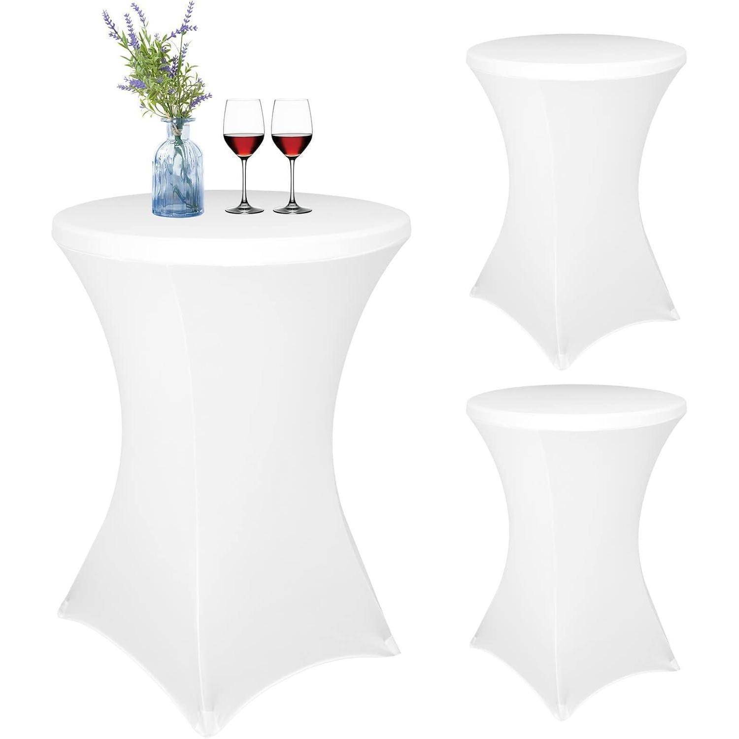 Hohe weiße Tische mit Stretchbezügen; ein Tisch hat eine Vase mit Blumen und zwei Gläsern Rotwein.