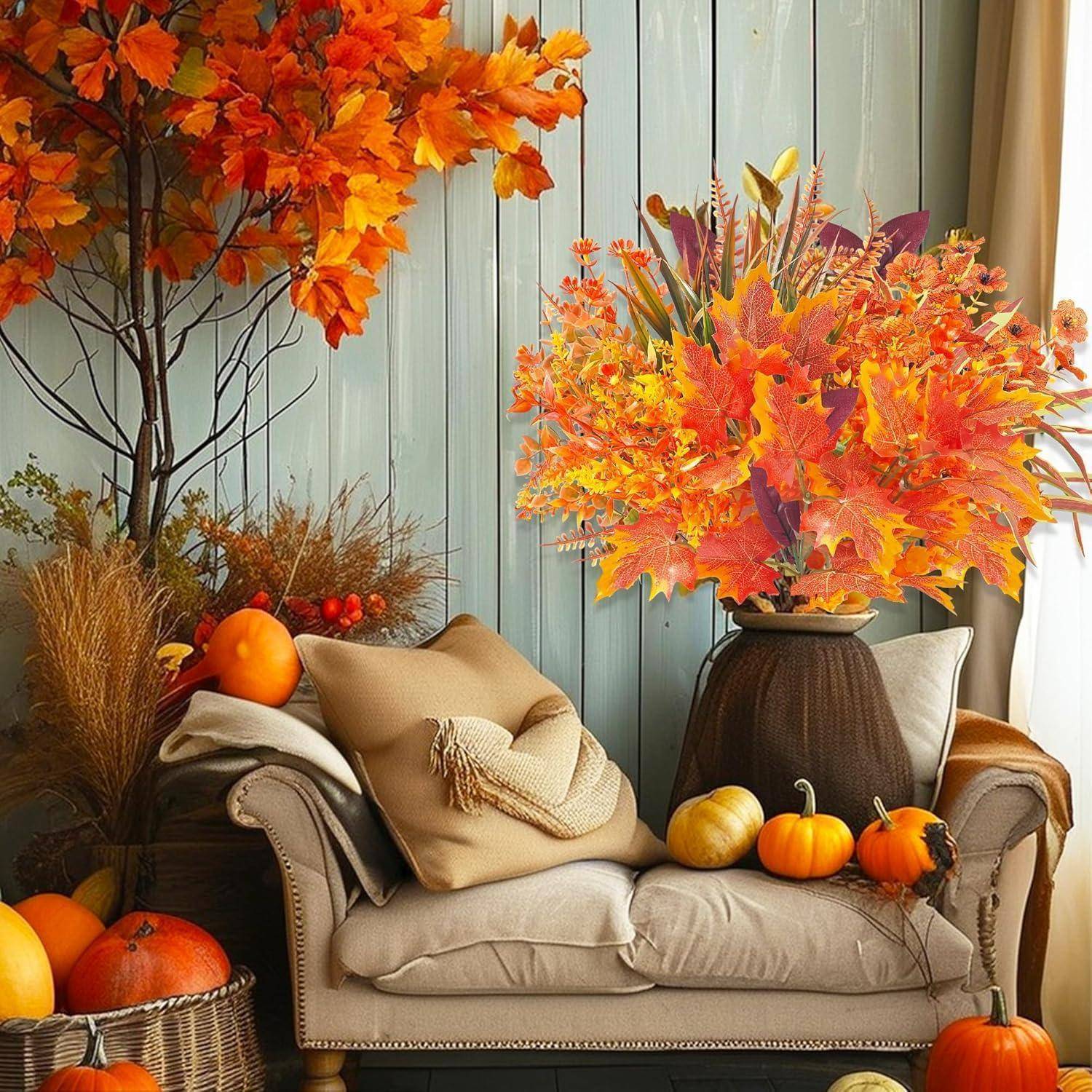 Eine gemütliche Sitzecke mit einem Sofa und Kissen, umgeben von bunten Herbstblättern und dekorativen Kürbissen, die eine warme, herbstliche Atmosphäre schaffen.