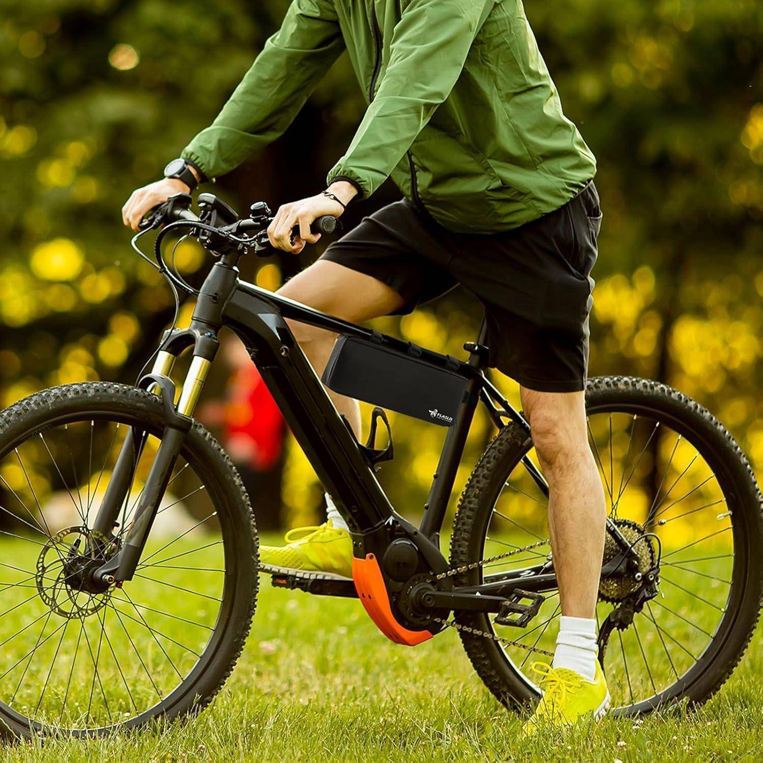Eine Person in einer grünen Jacke fährt ein schwarzes Fahrrad in einem Park. Der Hintergrund zeigt verschwommenes Grün und Sonnenlicht.